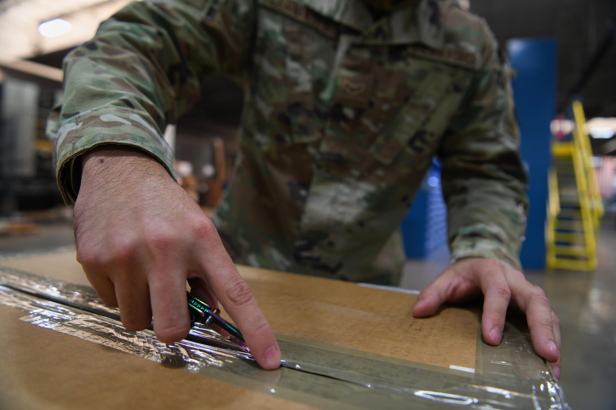 Airman 1st Class Atruro Cervantes, supply technician assigned to the 90th Logistics Readiness Squadron, opens a box with a personal knife at the Military Personnel Flight building on F.E. Warren Air Force Base, Wyoming, Feb. 9, 2022. The 90 LRS Material Management Flight must inspect incoming boxes to ensure they have received the correct assets and quantities. The department is working to provide knives for personnel in hopes of increasing efficiency. (U.S. Air Force photo by Airman 1st Class Charles Munoz)