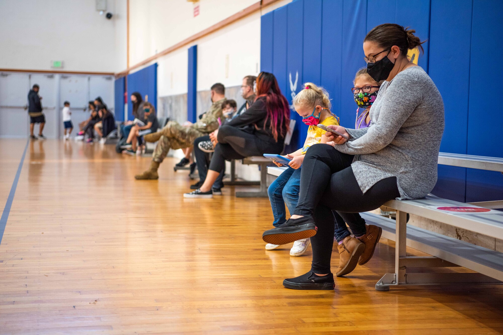 Parents and children sit on bleachers.