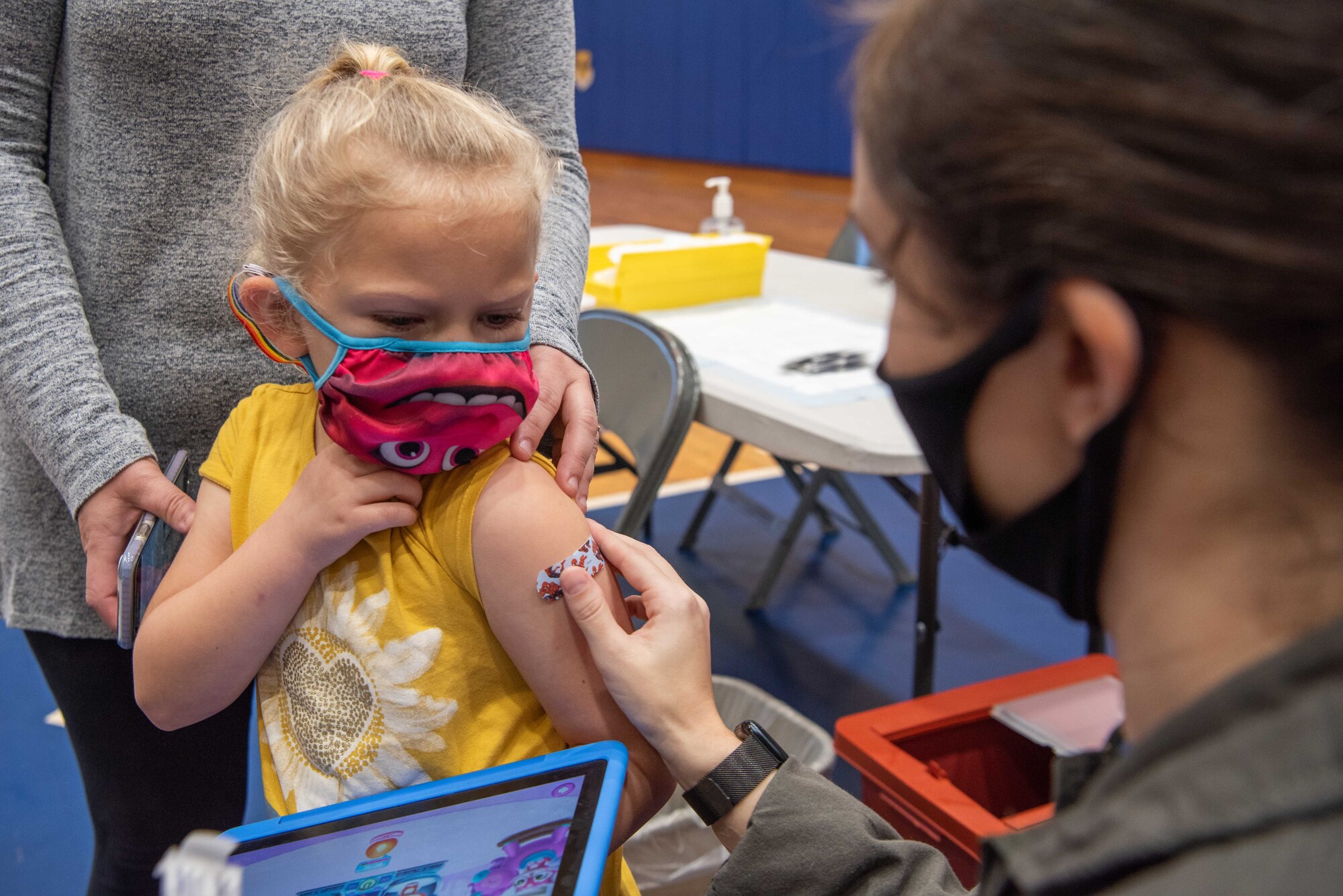 A technician gives a child a bandaid.
