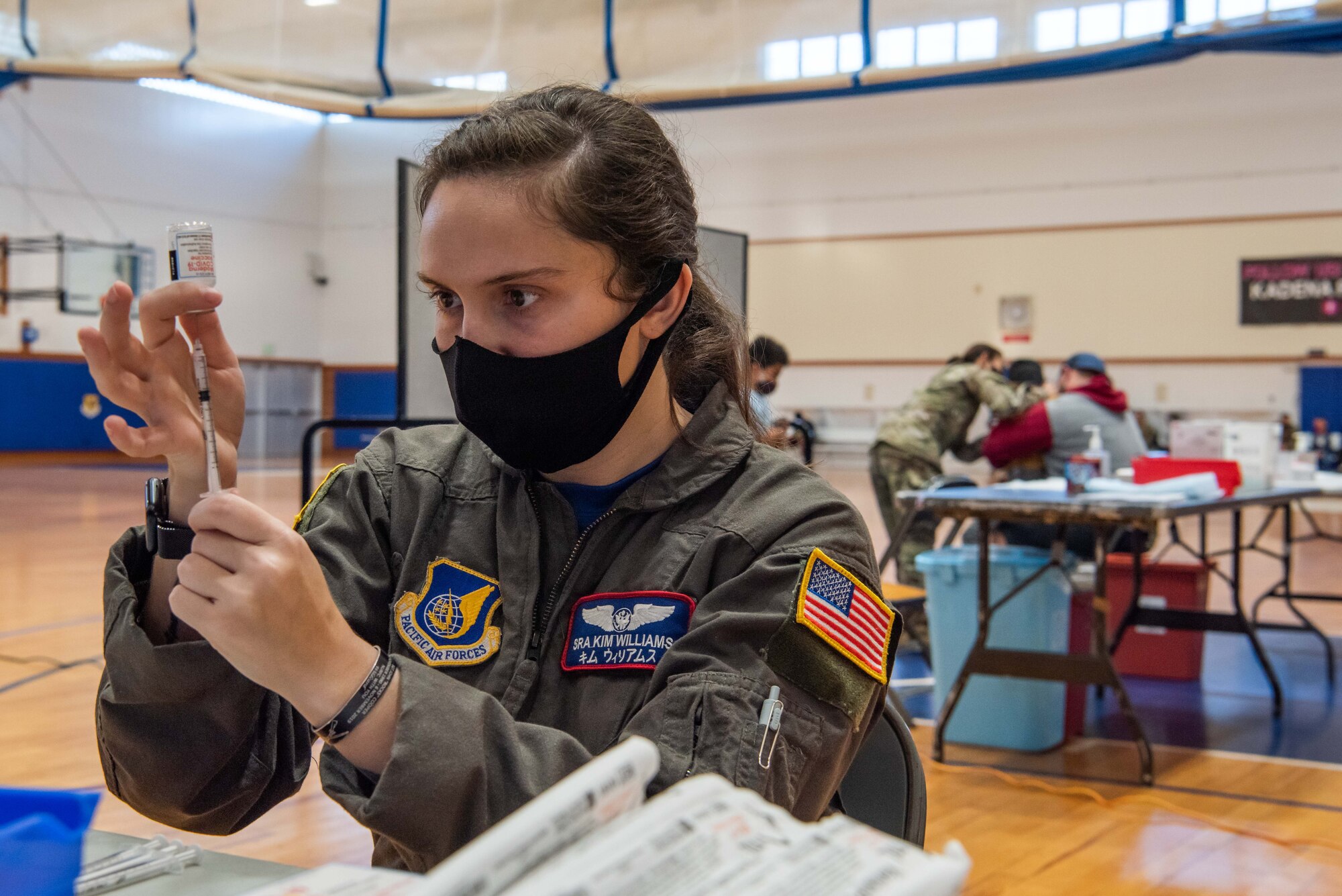 An Airman draws a syringe.