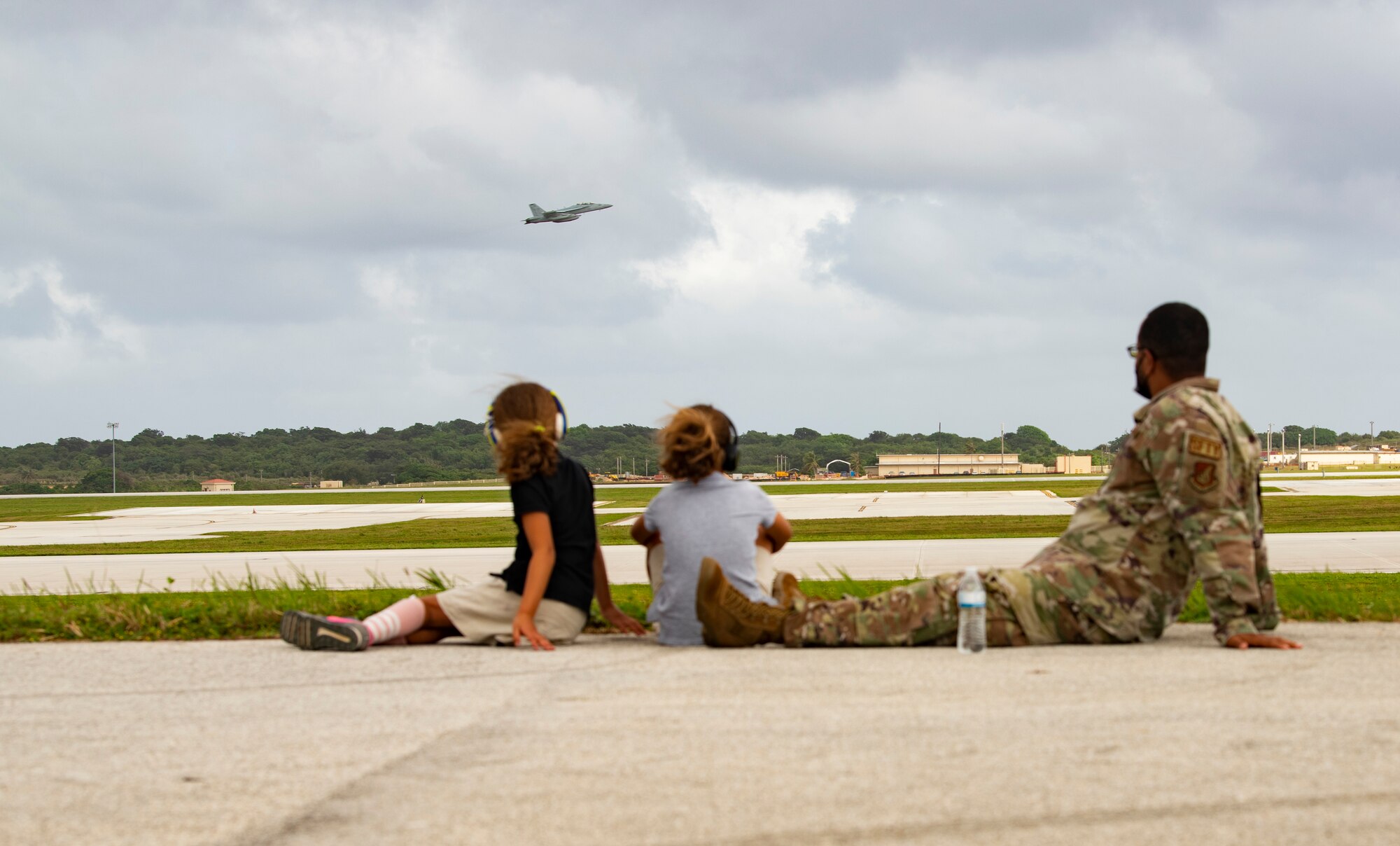 U.S. Air Force Senior Master Sgt. Philip Washington, 36th Wing Safety superintendent and his two daughters watch aircraft take off from Andersen Air Force Base, Guam, during a take-off viewing day for exercise Cope North 22, Feb. 9, 2022. Service members, their families and civic leaders were invited to the flight line to learn the importance of Cope North while observing aircraft capabilities.  Exercise Cope North is the U.S. Pacific Air Forces’ largest multilateral exercise and includes more than 2, 500 U.S. Airmen, Marines, and Sailors working alongside 1,000 combined Japan Air Self-Defense Force and Royal Australian Air Force counterparts.