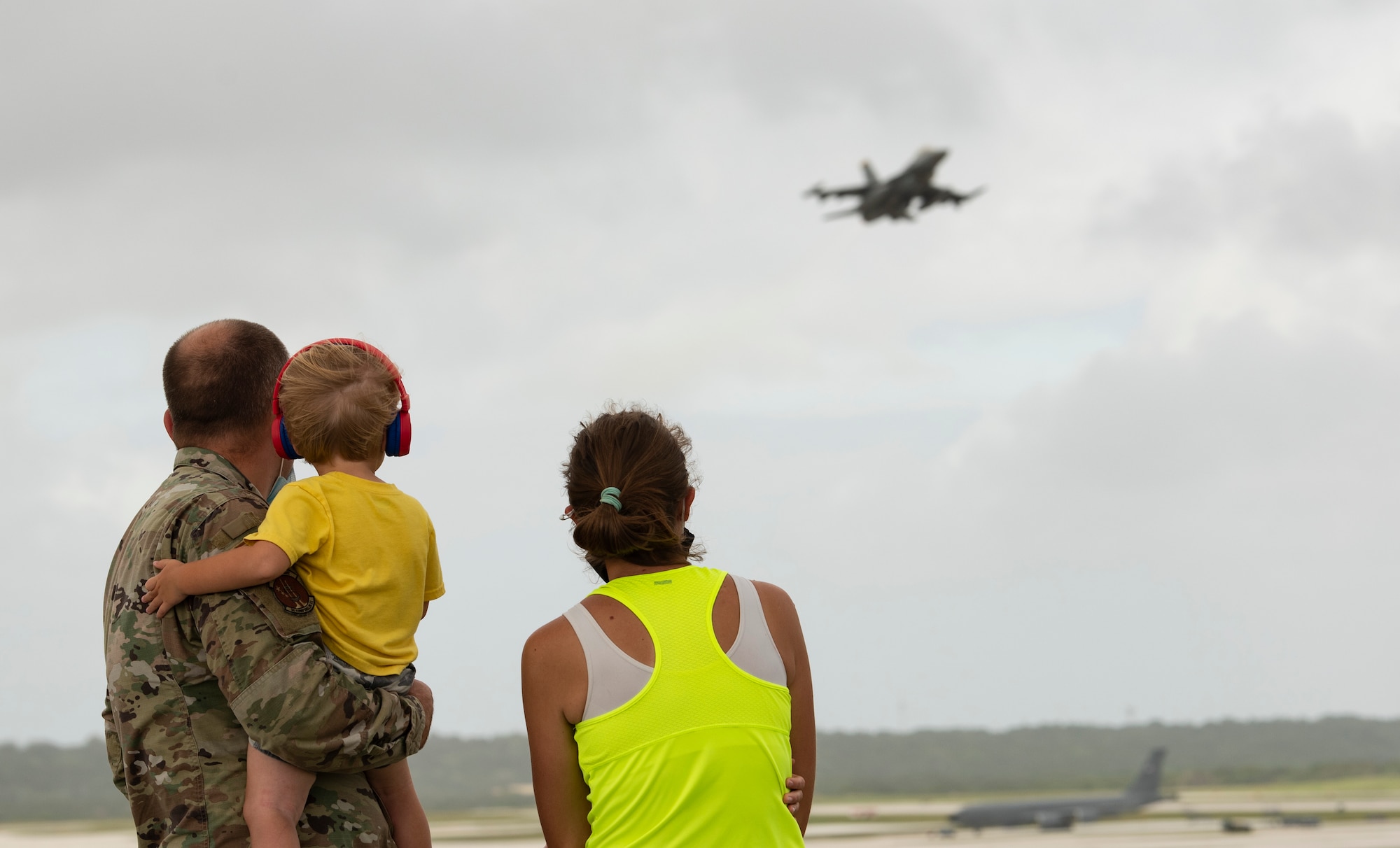 A family from Team Andersen watch aircraft take-off from Andersen Air Force Base during Exercise Cope North 22, Feb. 9, 2022. Service members, their families and civic leaders were invited to the flight line to learn the importance of Cope North while observing aircraft capabilities.  Exercise Cope North is the U.S. Pacific Air Forces’ largest multilateral exercise and includes more than 2, 500 U.S. Airmen, Marines, and Sailors working alongside 1,000 combined Japan Air Self-Defense Force and Royal Australian Air Force counterparts.