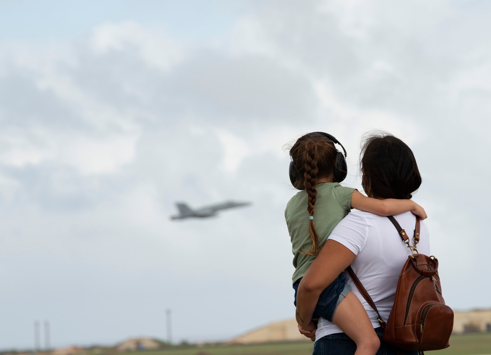 A family from Team Andersen watch aircraft take-off from Andersen Air Force Base during Exercise Cope North 22, Feb. 9, 2022. Service members, their families and civic leaders were invited to the flight line to learn the importance of Cope North while observing aircraft capabilities.  Exercise Cope North is the U.S. Pacific Air Forces’ largest multilateral exercise and includes more than 2, 500 U.S. Airmen, Marines, and Sailors working alongside 1,000 combined Japan Air Self-Defense Force and Royal Australian Air Force counterparts.