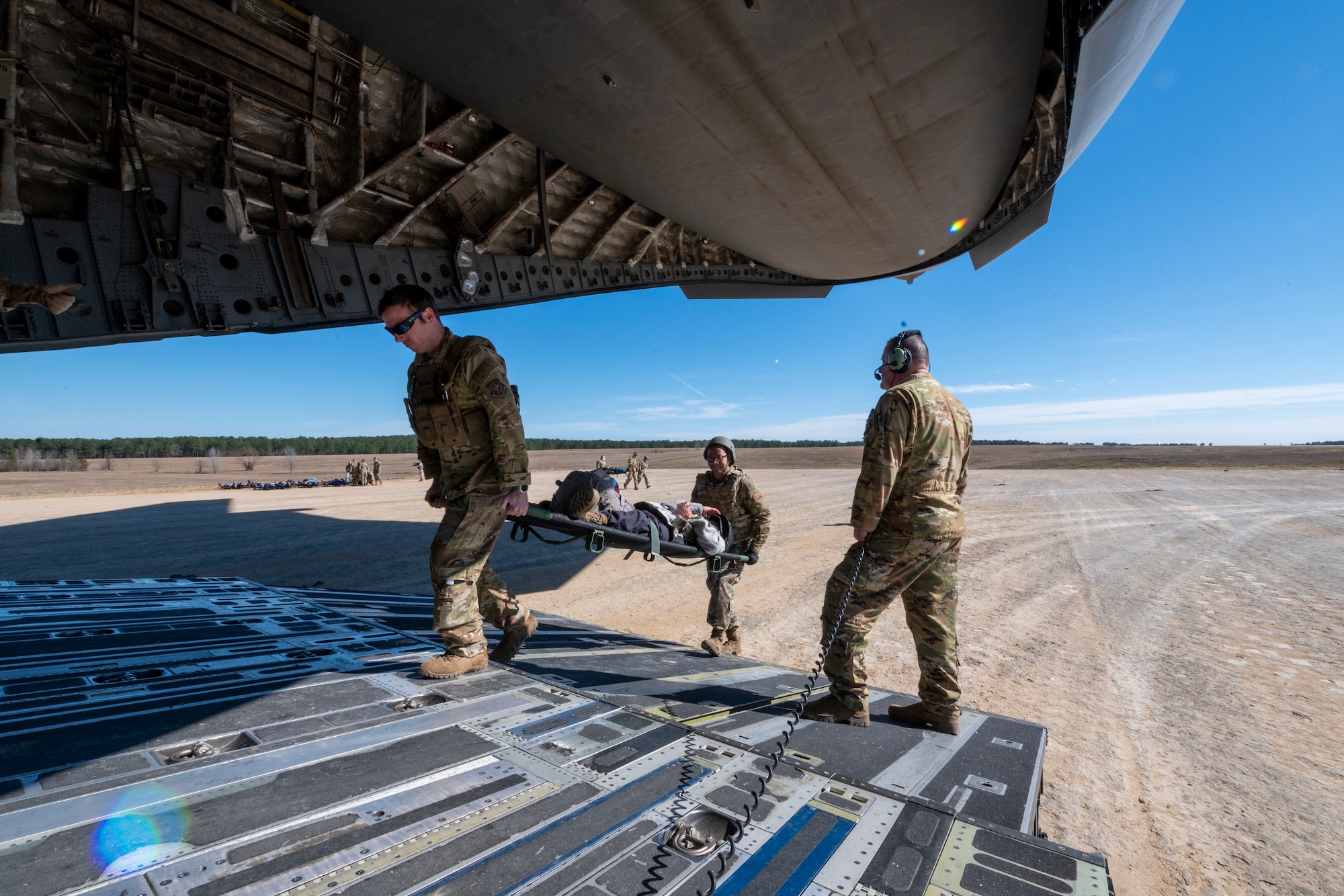 U.S. Air Force Chief Master Sgt. Mark Synder, a loadmaster with the 167th Airlift Squadron, waits for patients to be loaded by aeromedical evacuation specialists during exercise Green Flag Little Rock 22-03 at Ft. Polk, Louisiana, Jan. 13, 2022. GFLR 22-03 focused on three joint-accredited items: combat airlift; survival, evasion, resistance and escape; and aeromedical evacuation.