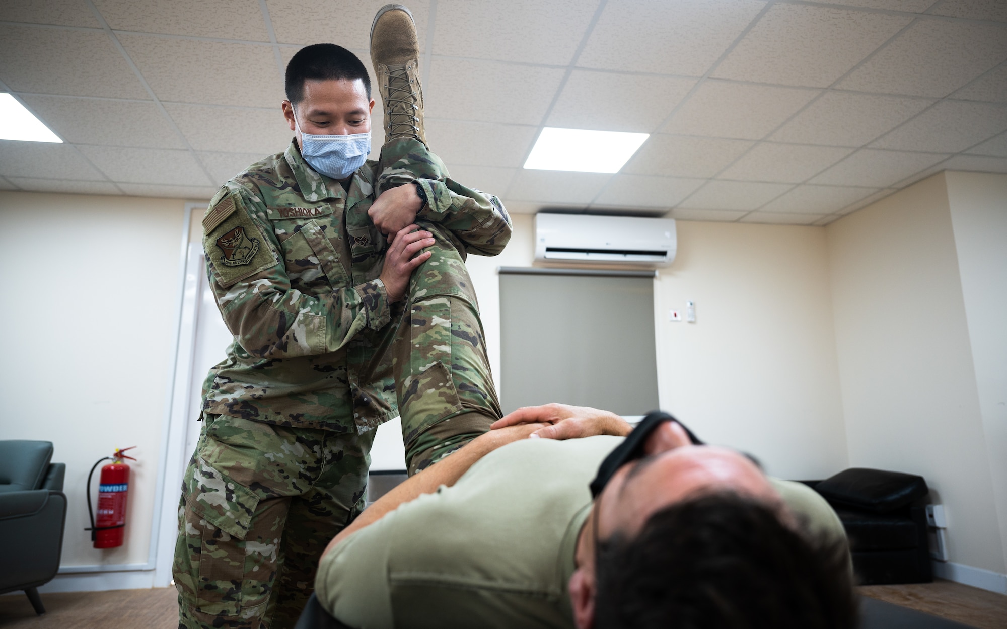 U.S. Air Force Senior Airman Koji Yoshioka, 378th Expeditionary Medical Group physical therapy technician, works with a patient at Prince Sultan Air Base, Kingdom of Saudi Arabia, Dec. 30, 2021. PSAB's physical therapy team provides traditional physical therapy, evaluations, manual therapy, and exercise therapy to service members deployed to the base. (U.S. Air Force photo by Senior Airman Jacob B. Wrightsman)