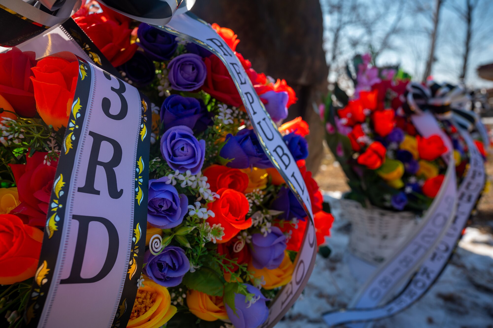 Bouquets of flowers are set at the Hill 180 Bayonet Hill monument