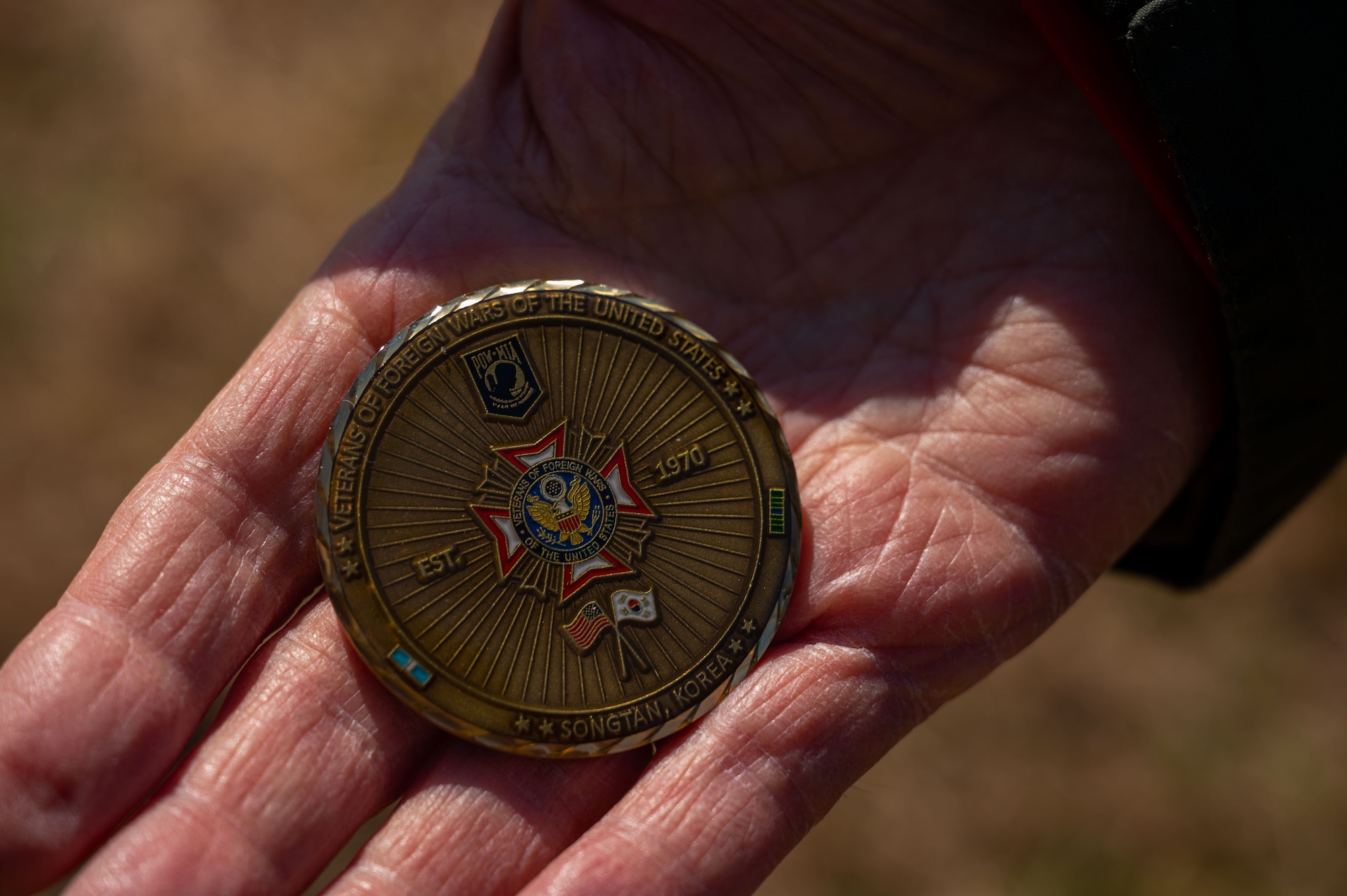 Earnest Lee, Korean War veteran and Hill 180 remembrance ceremony distinguished guest, presents a coin to a guest of honor