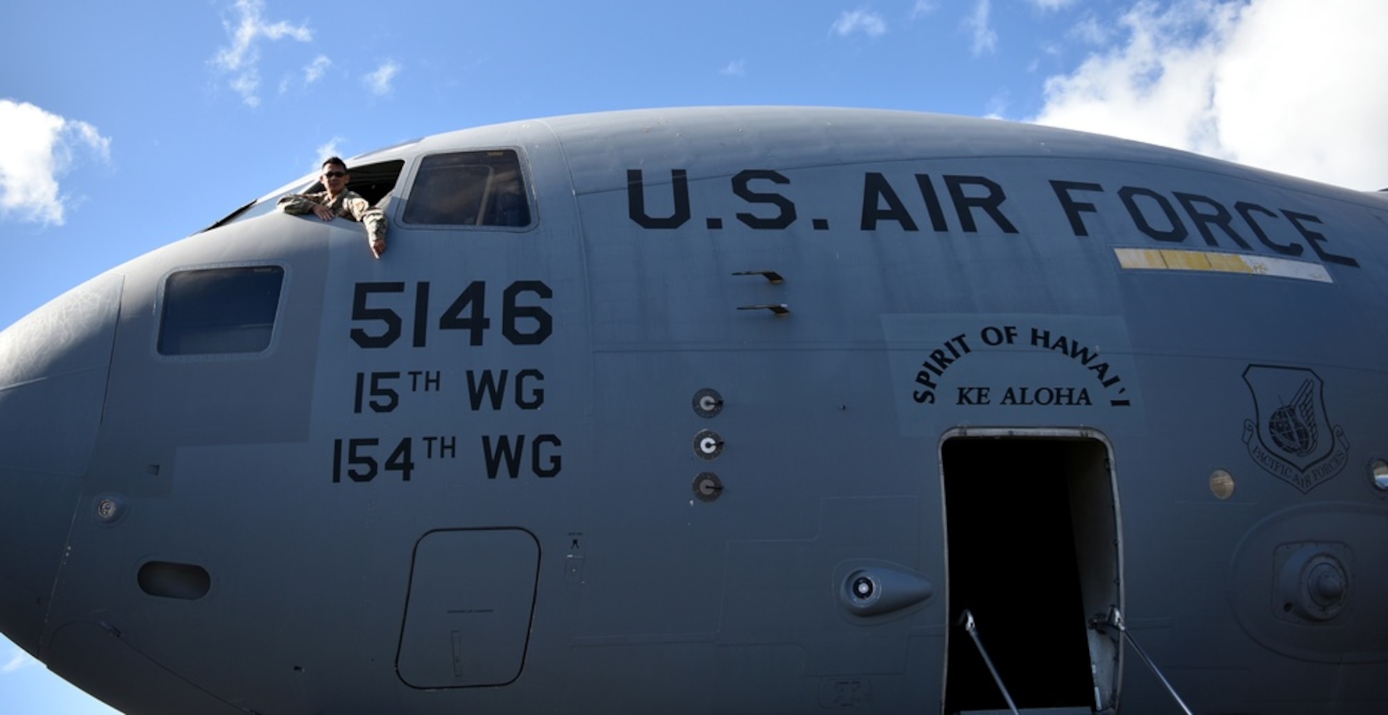U.S. Air Force Master Sgt. Rafeal Dela Sierra, 154th Aircraft Maintenance Squadron dedicated crew chief, points to tail number 5146 through the flightdeck window on the 16th anniversary of the first Hawai’i based C-17 Globemaster III arrival to Joint Base Pearl Harbor-Hickam, Hawaii, Feb. 8, 2022. The 15th Wing and 154th Hawai’i Air National guard have jointly operated and maintained the aircraft since its arrival. This frame is called Total Force Integration; Each contributing component of the TFI offers unique capabilities and strengths, and the Air Force leverages their varied capacities to meet National Military Objectives. (U.S. Air Force photo by Tech. Sgt. Anthony Nelson Jr.)