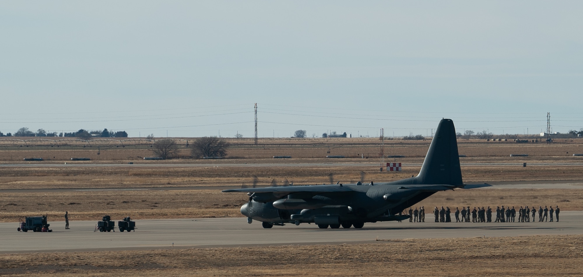 A U.S. Air Force AC-130W Stinger II gunship from the 16th Special Operations Squadron taxis into a parking spot surrounded by members of the 16 SOS after a memorial flyover honoring the crew of Spirit 03 at Cannon Air Force Base, New Mexico, Jan. 31, 2022. Spirit 03 was the last AC-130 gunship shot down in combat, lost during Operation Desert Storm. The 16 SOS honored the crew by performing live fire training at the Spirit live fire range at Melrose Air Force Range, conducted a memorial flyover at Cannon, and held a remembrance brief after the flights detailing the story of the aircrew and advancements made as a result of the loss of Spirit 03. (U.S. Air Force photo by Senior Airman Christopher Storer)