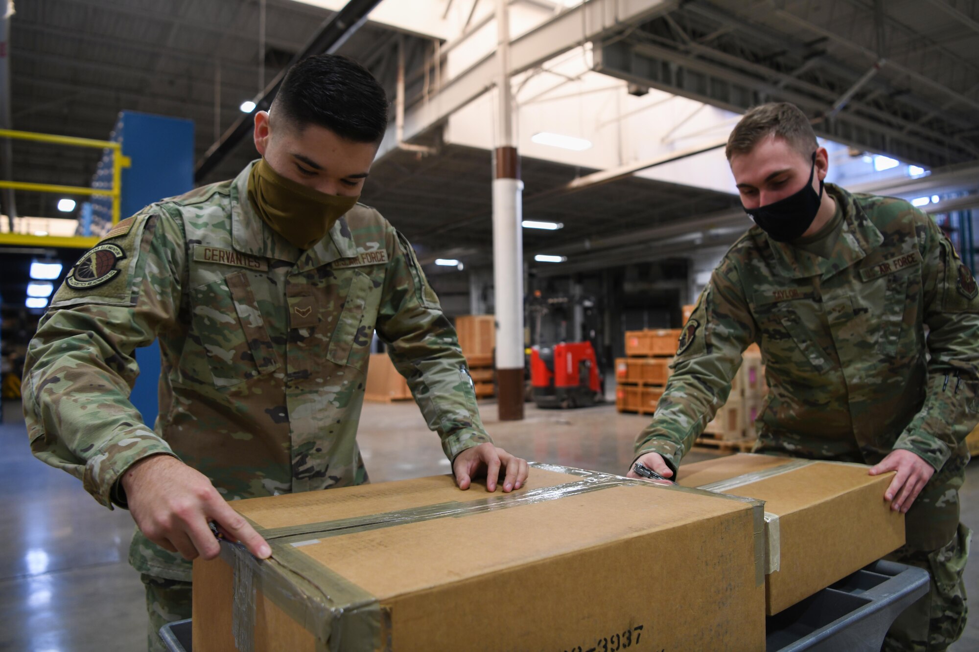Airman 1st Class Atruro Cervantes, supply technician (left), and Airman 1st Class Ryan Taylor, customer service journeyman, both assigned to the 90th Logistics Readiness Squadron, open boxes at the Military Personnel Flight building on F.E. Warren Air Force Base, Wyoming, Feb. 9, 2022. The 90 LRS Material Management Flight must inspect incoming boxes to ensure they have received the correct assets and quantities. These assets are distributed throughout F.E. Warren AFB to support the mission of strategic nuclear deterrence. (U.S. Air Force photo by Airman 1st Class Charles Munoz)
