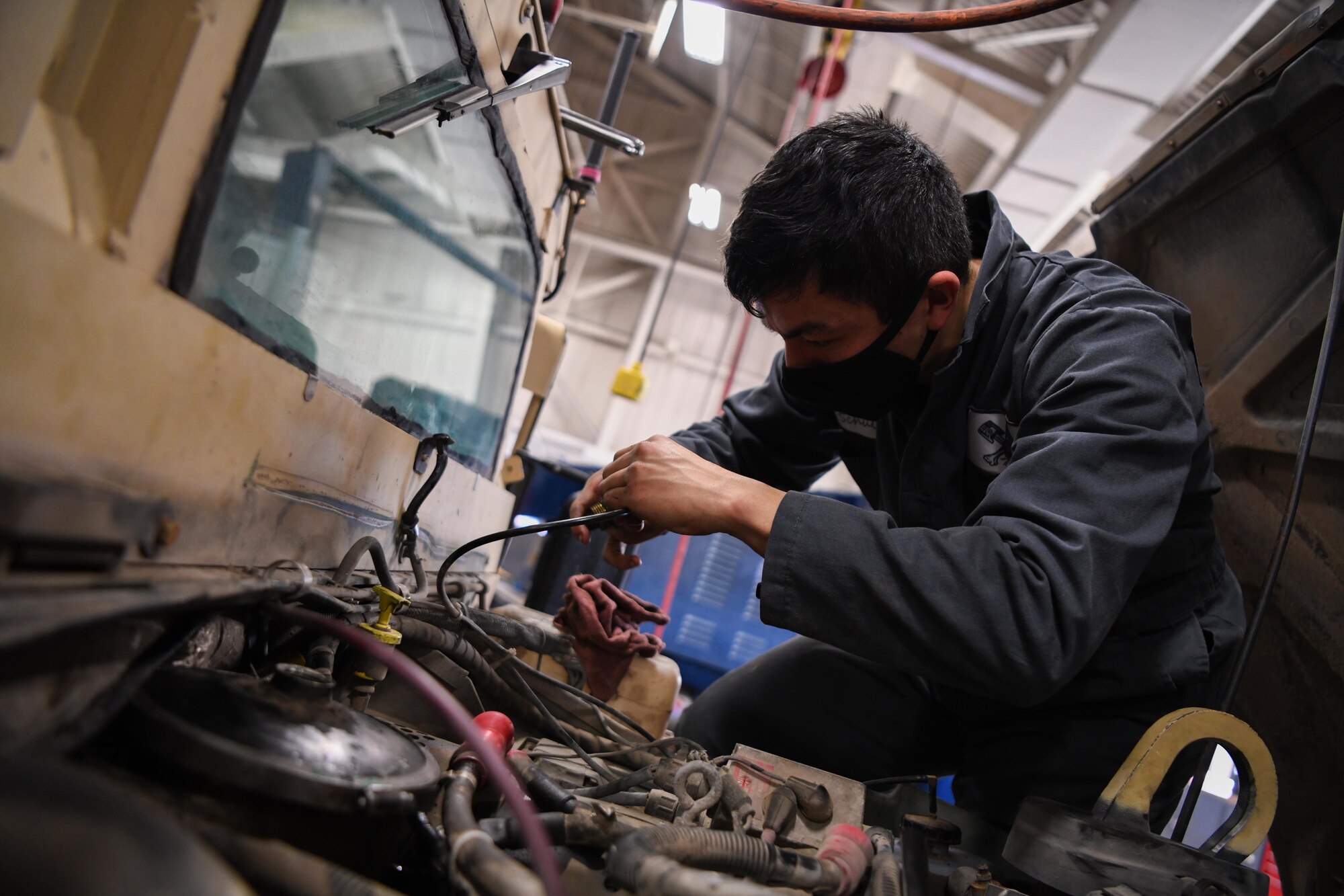 Airman 1st Class Indigo Schultz, mission generation vehicular equipment maintenance technician at the 90th Logistics Squadron, conducts a preventative maintenance inspection on a Humvee at the 90 LRS Vehicle Maintenance Flight warehouse on F.E. Warren Air Force Base, Wyoming, Feb. 8, 2022. PMIs are conducted to ensure vehicles are in working order after set intervals of time. The Vehicle Maintenance Flight is responsible for maintaining and repairing vehicles used in the mission of strategic nuclear deterrence. (U.S. Air Force photo by Airman 1st Class Charles Munoz)