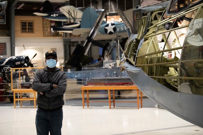 A Building Partner Aviation Capacity Seminar 22A participant poses beside an aviation display Jan. 28, 2022, in the Naval Aviation Museum at Naval Air Station Pensacola, Florida.