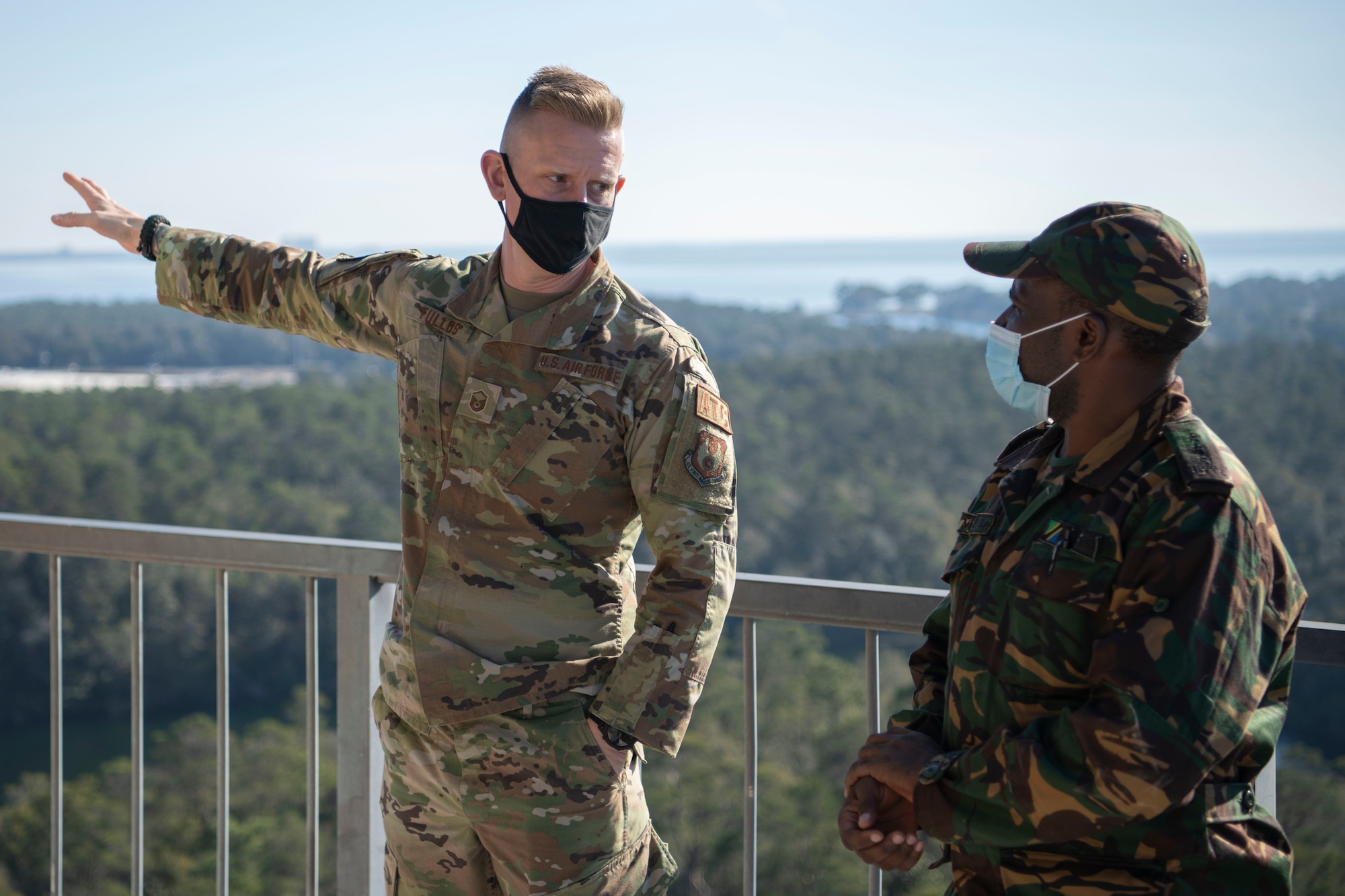 U.S. Air Force Master Sgt. John Tullos, a 96th Operations Support Squadron tower chief controller, interacts with a Building Partner Aviation Capacity Seminar 22A participant Jan. 27, 2022, at Eglin Air Force Base, Florida.