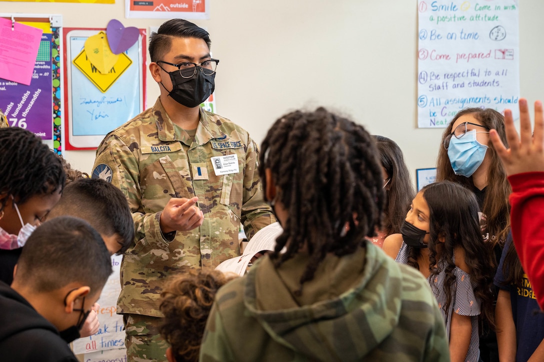 A guardian talks to children in a classroom.