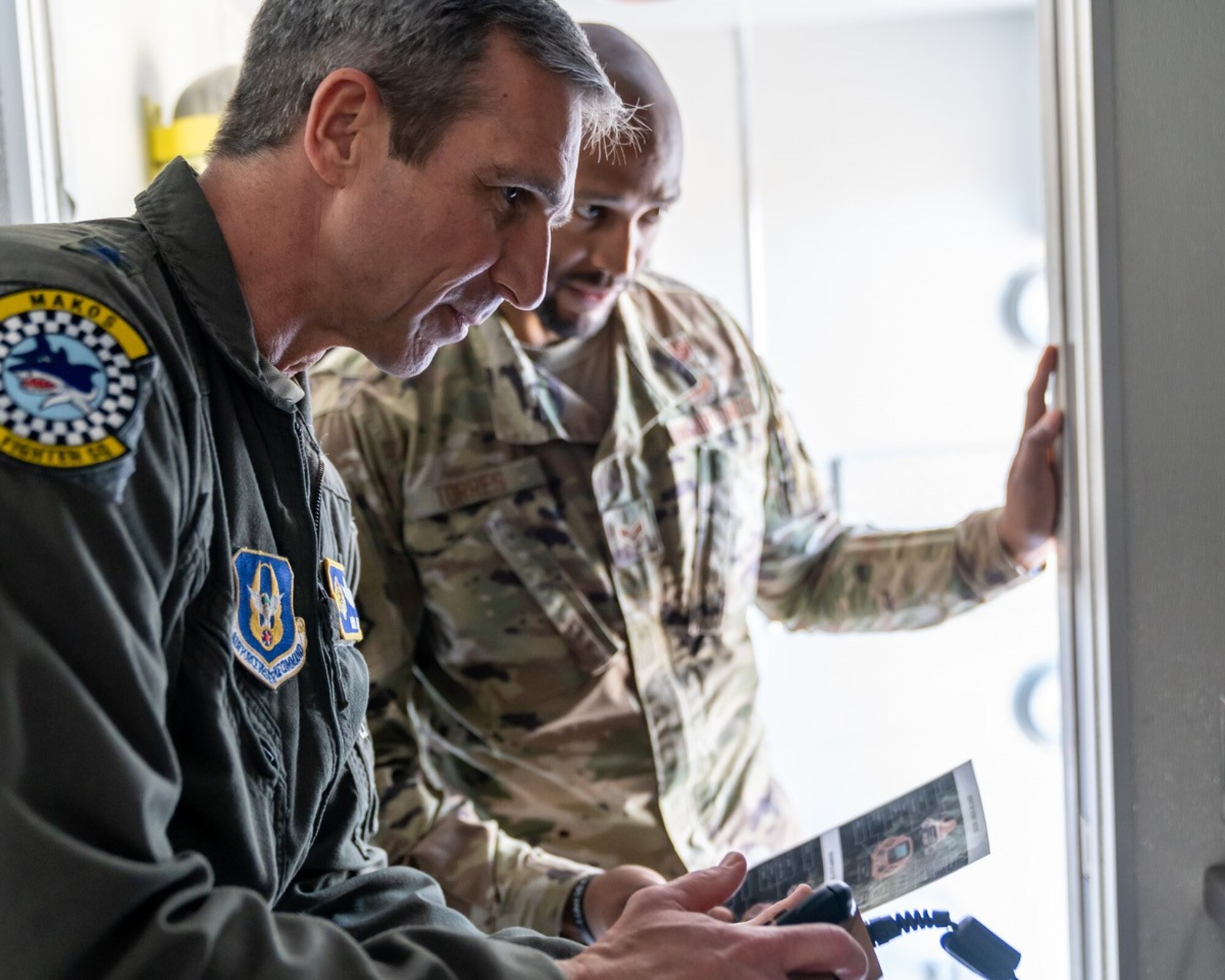 Maj. Gen. Bryan Radliff, 10th Air Force commander, controls a Man Transportable Robot System while Senior Airman Frederick Torres, 482nd Explosive Ordnance Disposal Team, provides assistants at Homestead Air Reserve Base, Florida, Feb. 7, 2022. MTRS is a remotely operated, medium-sized robotic system that offers a standoff capability to detect, confirm, identify and dispose of hazards. (U.S. Air Force photo by Tech. Sgt. Lionel Castellano)