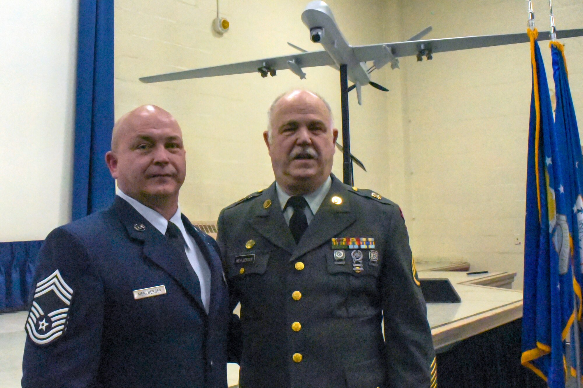 A man in Air Force Dress blues stands next to another man in Army dress uniform.