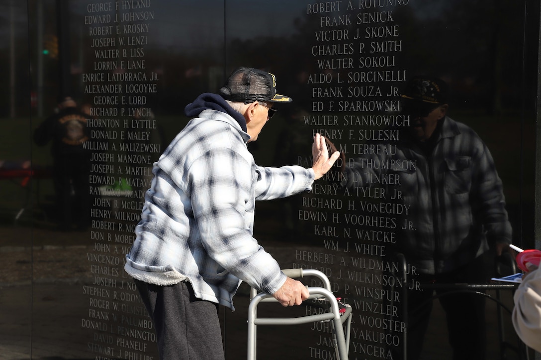 An unidentified WWII veteran places his hand on the names of the Connecticut fallen at the National Iwo Jima Memorial in New Britain CT.(Courtesy Photo)