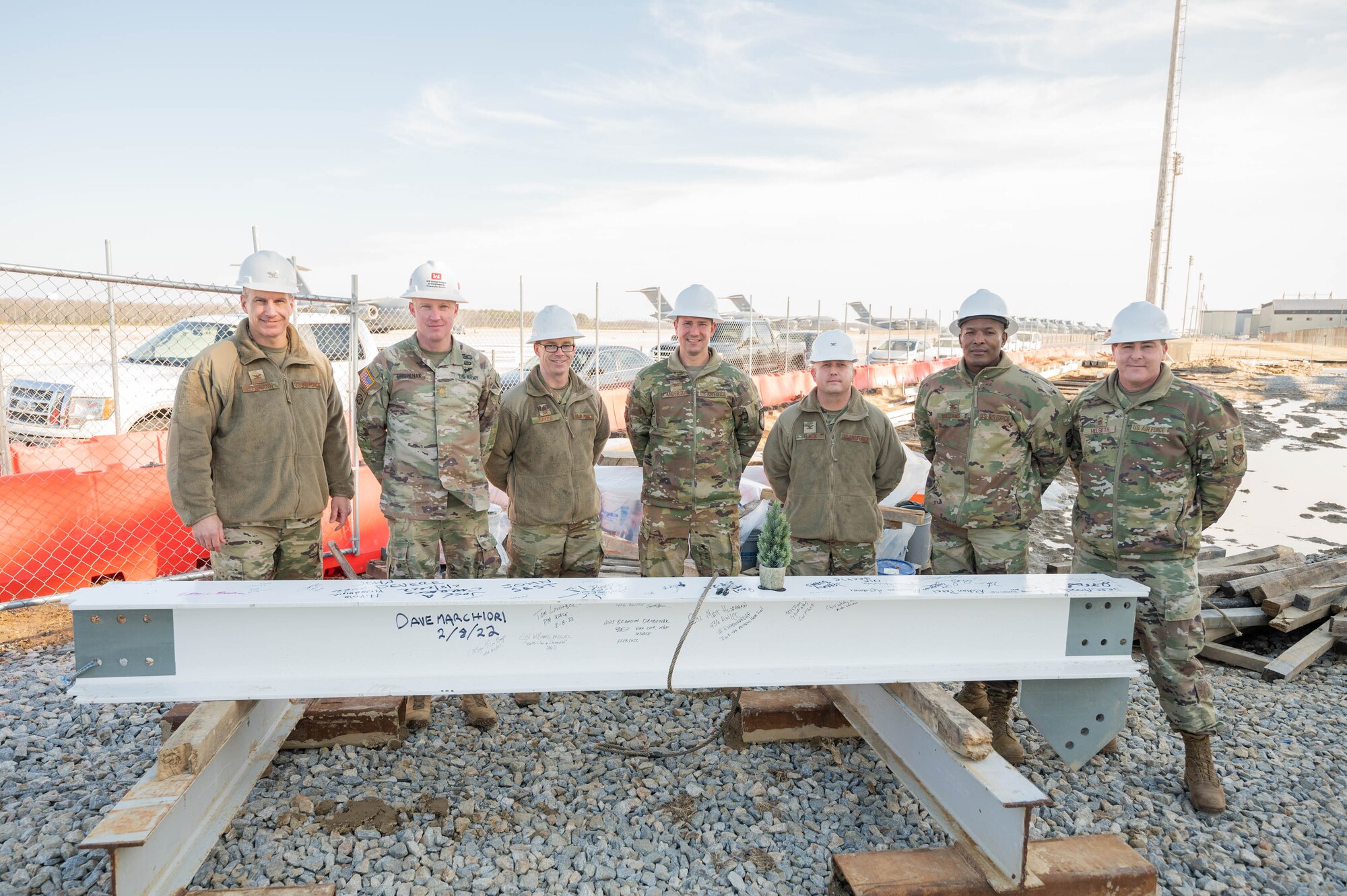 Team Dover senior leaders stand behind a steel beam on Dover Air Force Base, Delaware, Feb. 8, 2022. The beam was the final piece of the structural frame installed on Dover AFB’s newest state-of-the-art aircraft hangar. The $41.2 million project is scheduled for completion in the fall of 2022. (U.S. Air Force photo by Mauricio Campino)