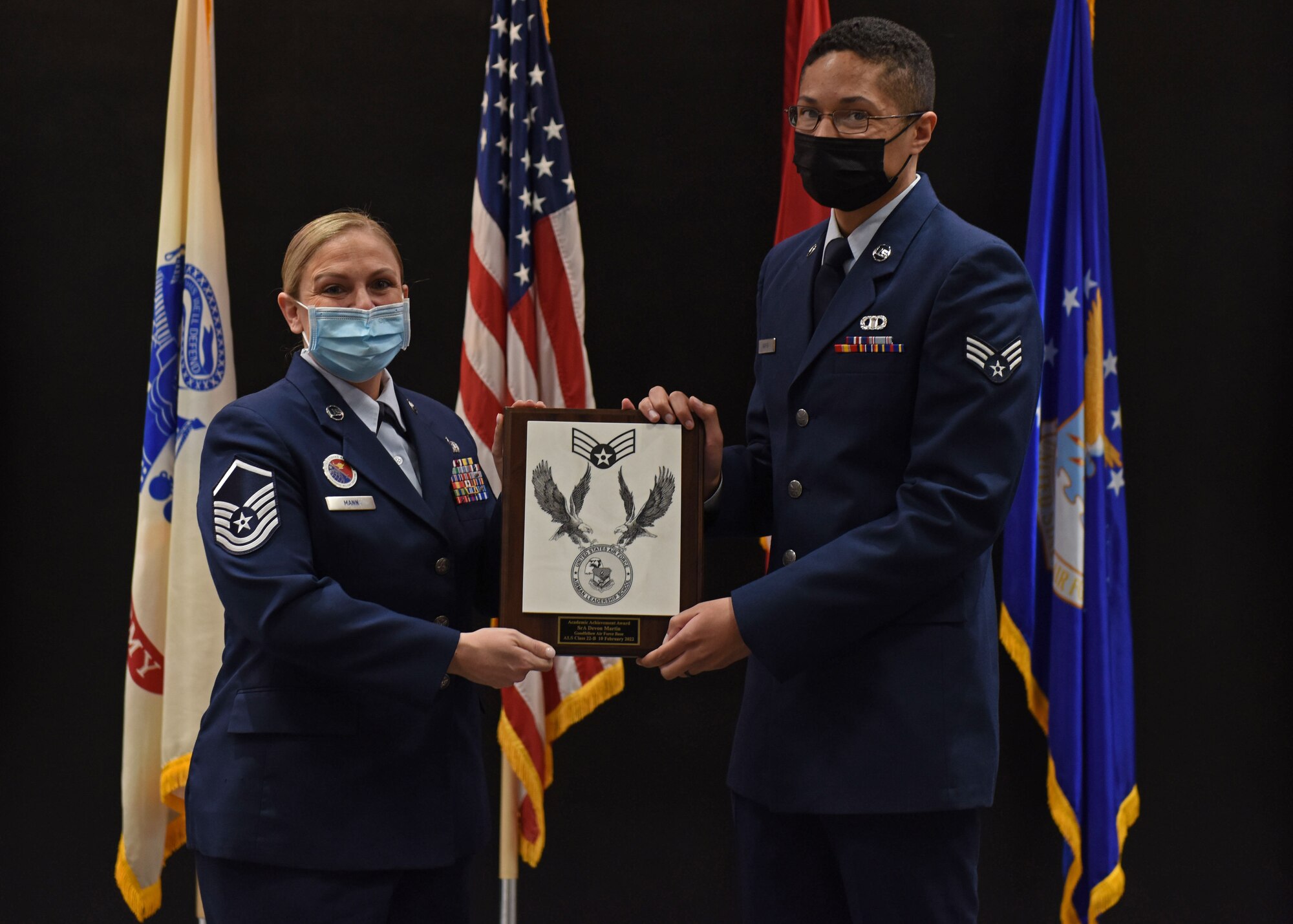 U.S. Air Force Master Sgt. Elizabeth Mann, Goodfellow Airman Leadership School commandant, presents Senior Airman Devon Martin, 47th Operations Support Squadron air traffic control rapcon, the Academic Achievement Award during the ALS graduation ceremony on Goodfellow Air Force Base, Texas, Feb. 10, 2022. The Academic Achievement Award recognizes a student who demonstrated academic excellence in all performance tasks and the capstone exercise. (U.S. Air Force photo by Airman 1st Class Sarah Williams)