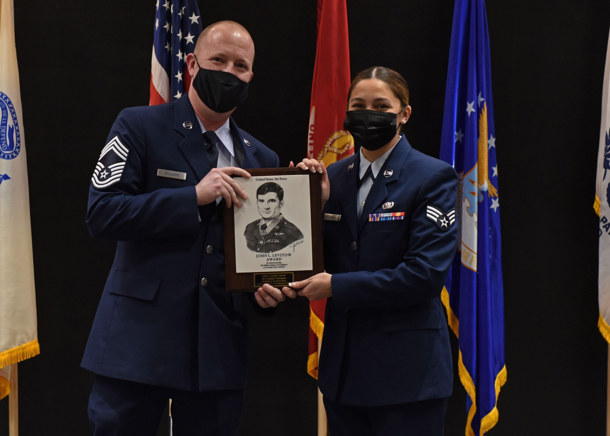 U.S. Air Force Chief Master Sgt. Christopher T. Williams, 17th Communications Squadron senior enlisted leader, presents Senior Airman Kaihla Critzman, 17th Logistics Readiness Squadron non-commissioned officer of deployments, the John L. Levitow Award during the Airman Leadership School graduation ceremony on Goodfellow Air Force Base, Texas, Feb. 10, 2022. The John L. Levitow Award is presented to the student that demonstrated the highest degree of excellence as a leader and a scholar. (U.S. Air Force photo by Airman 1st Class Sarah Williams)