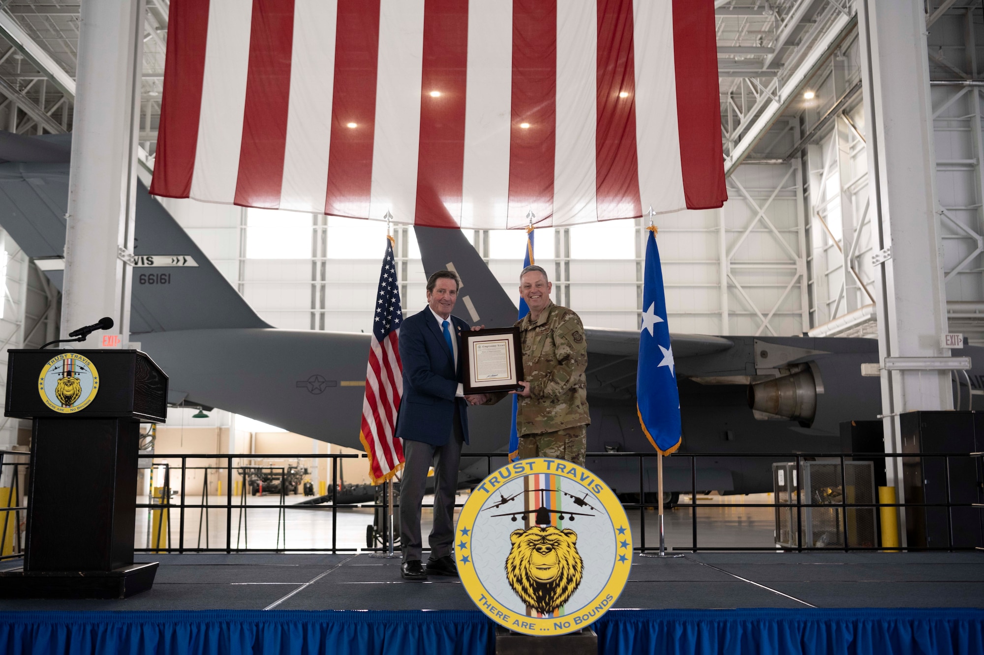 A congressman hands a document to an Airman