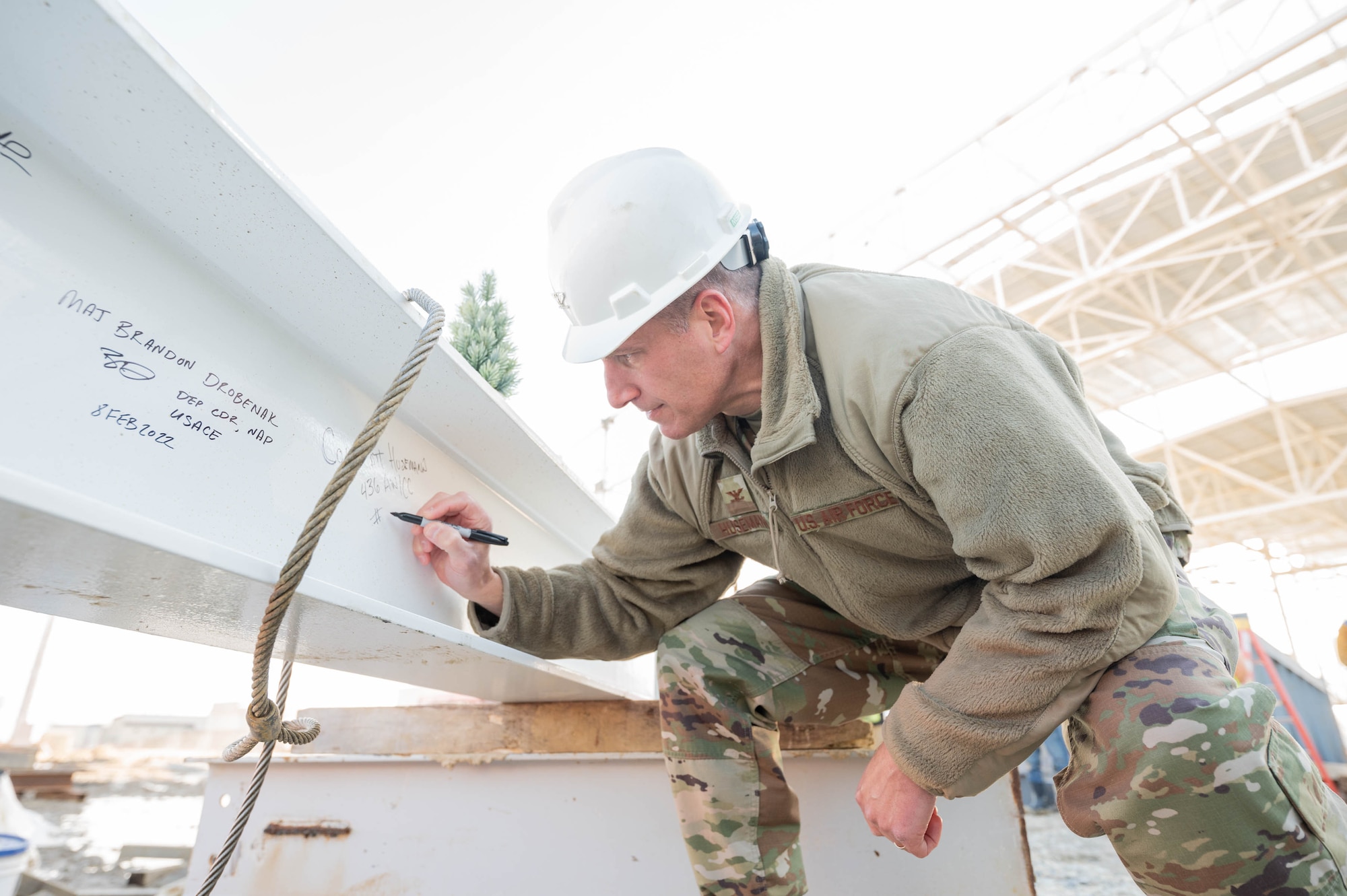 Col. Matt Husemann, 436th Airlift Wing commander, signs his name on a steel beam at Dover Air Force Base, Delaware, Feb. 8, 2022. The beam was the final piece of the structural frame installed on Dover AFB’s newest state-of-the-art aircraft hangar. The $41.2 million project is scheduled for completion in the fall of 2022. (U.S. Air Force photo by Mauricio Campino)