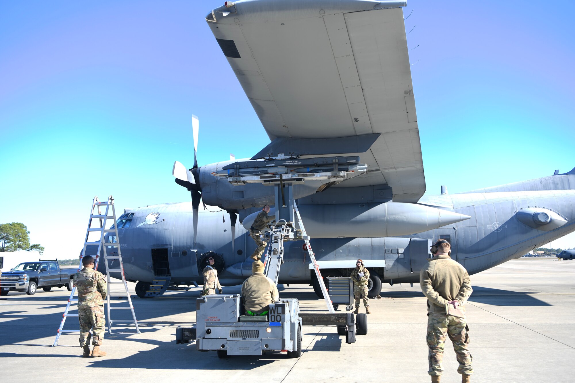 Air Commandos assigned to the 4th Aircraft Maintenance Unit attach a trainer BRU-61 bomb to an AC-130J Ghostrider during the 1st Special Operations Wing’s Weapons Load Crew of the 4th Quarter Competition Jan. 7, 2022 on the flightline at Hurlburt Field, Florida.