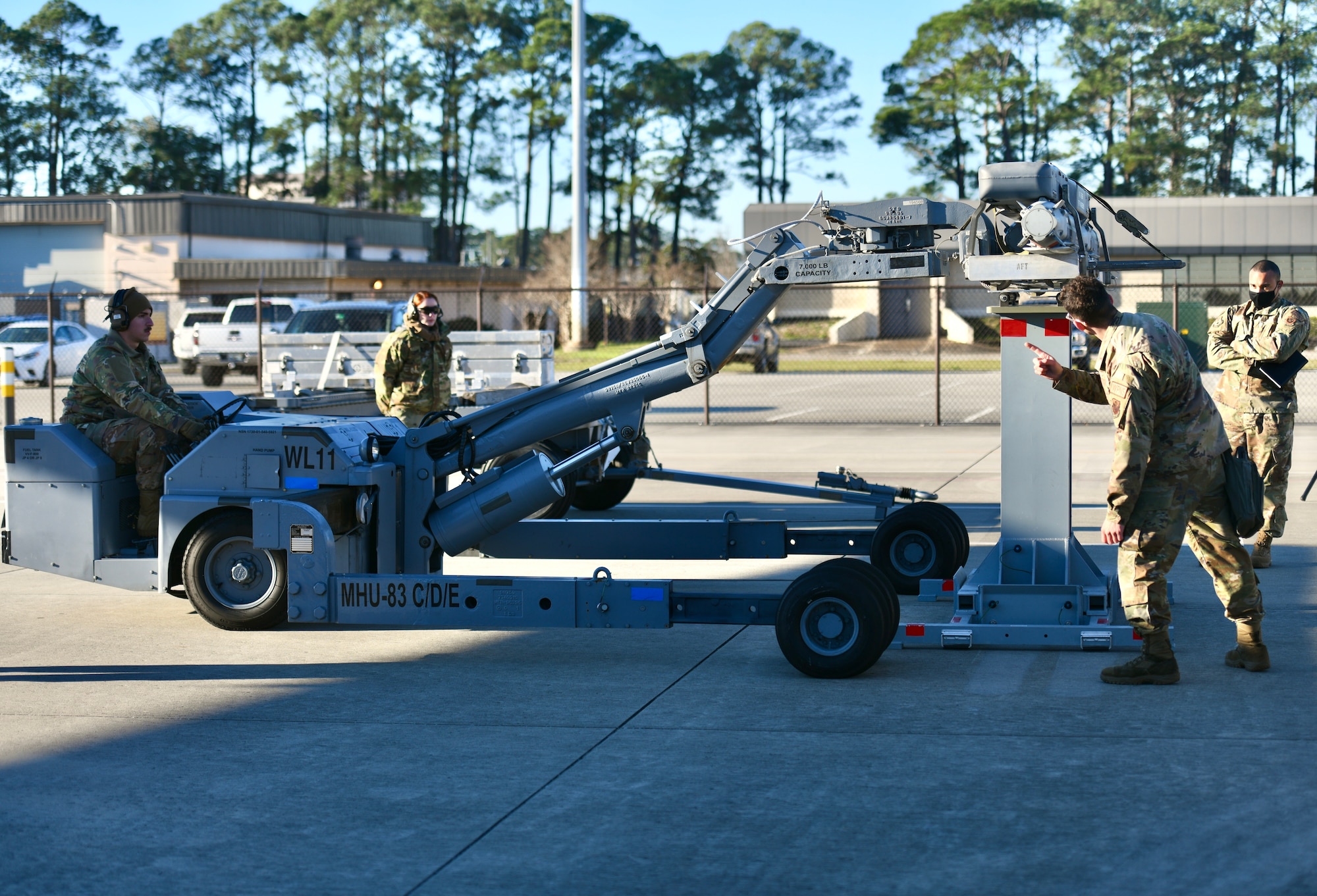 Air Commandos assigned to the 73rd Aircraft Maintenance Unit prepare to lift a trainer BRU-61 bomb off of its storage rack during the 1st Special Operations Wing’s Weapons Load Crew of the 4th Quarter Competition Jan. 7, 2022 on the flightline at Hurlburt Field, Florida.