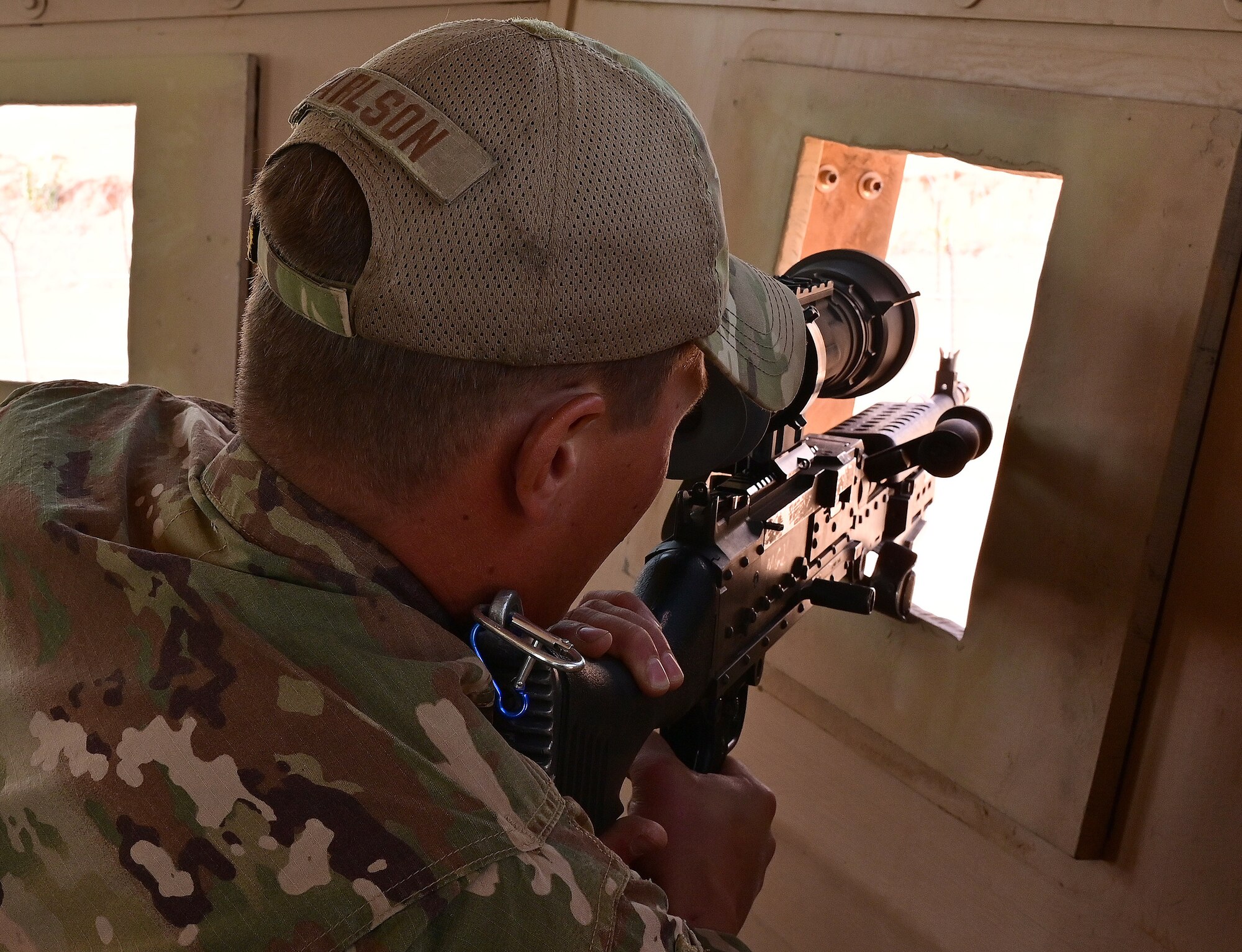 U.S. Air Force Tech. Sgt. Tyler Carlson, 409th Expeditionary Security Forces Squadron plans and programs, demonstrates the increased  visibility the updated firing port shields provide for the guard towers at Nigerien Air Base 201, Agadez, Niger,  Feb. 8, 2022. 

Four innovative Airmen developed tower modifications creating a better firing platform, increased field of view and a more comfortable work environment for Defenders. (U.S. Air Force photo by Tech. Sgt. Stephanie Longoria)