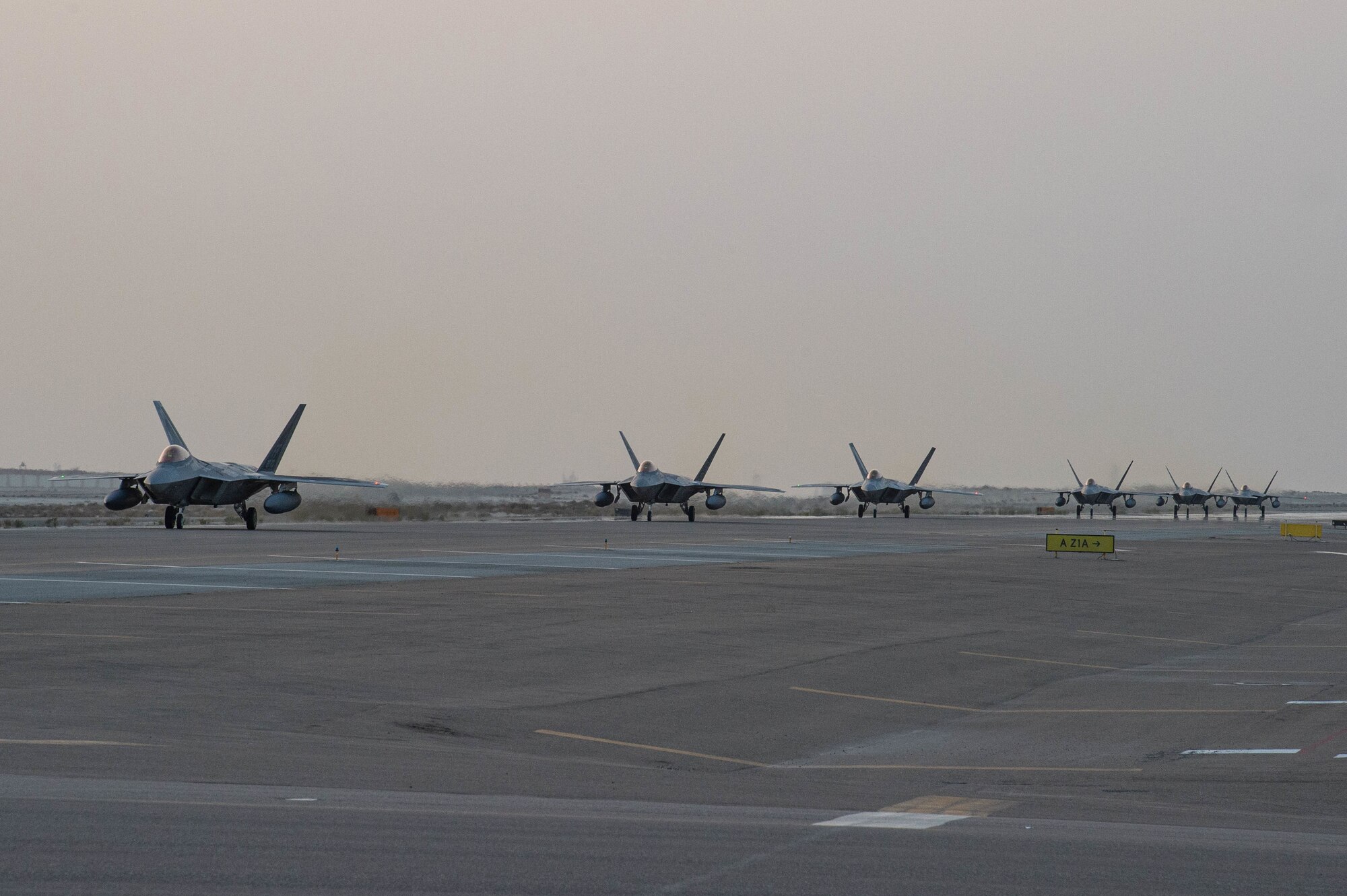 6 F-22 Raptors taxi on a flightline