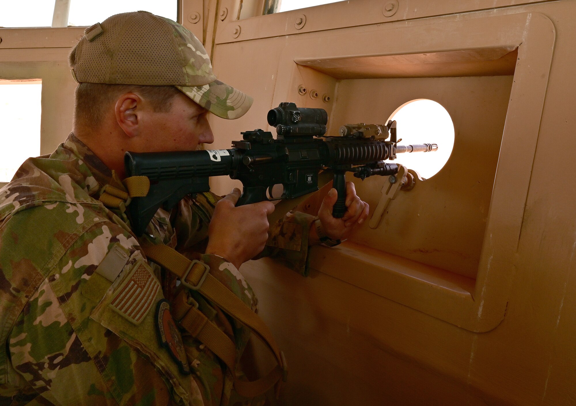 U.S. Air Force Tech. Sgt. Tyler Carlson, 409th Expeditionary Security Forces Squadron plans and program, demonstrates how the expanded firing port increases field of view for Defenders at Nigerien Air Base 201, Agadez, Niger, Feb. 8, 2022. Modifications to the towers  created a better firing platform, increased field of view and a more comfortable work environment for Defenders. (U.S. Air Force photo by Tech. Sgt Stephanie Longoria)