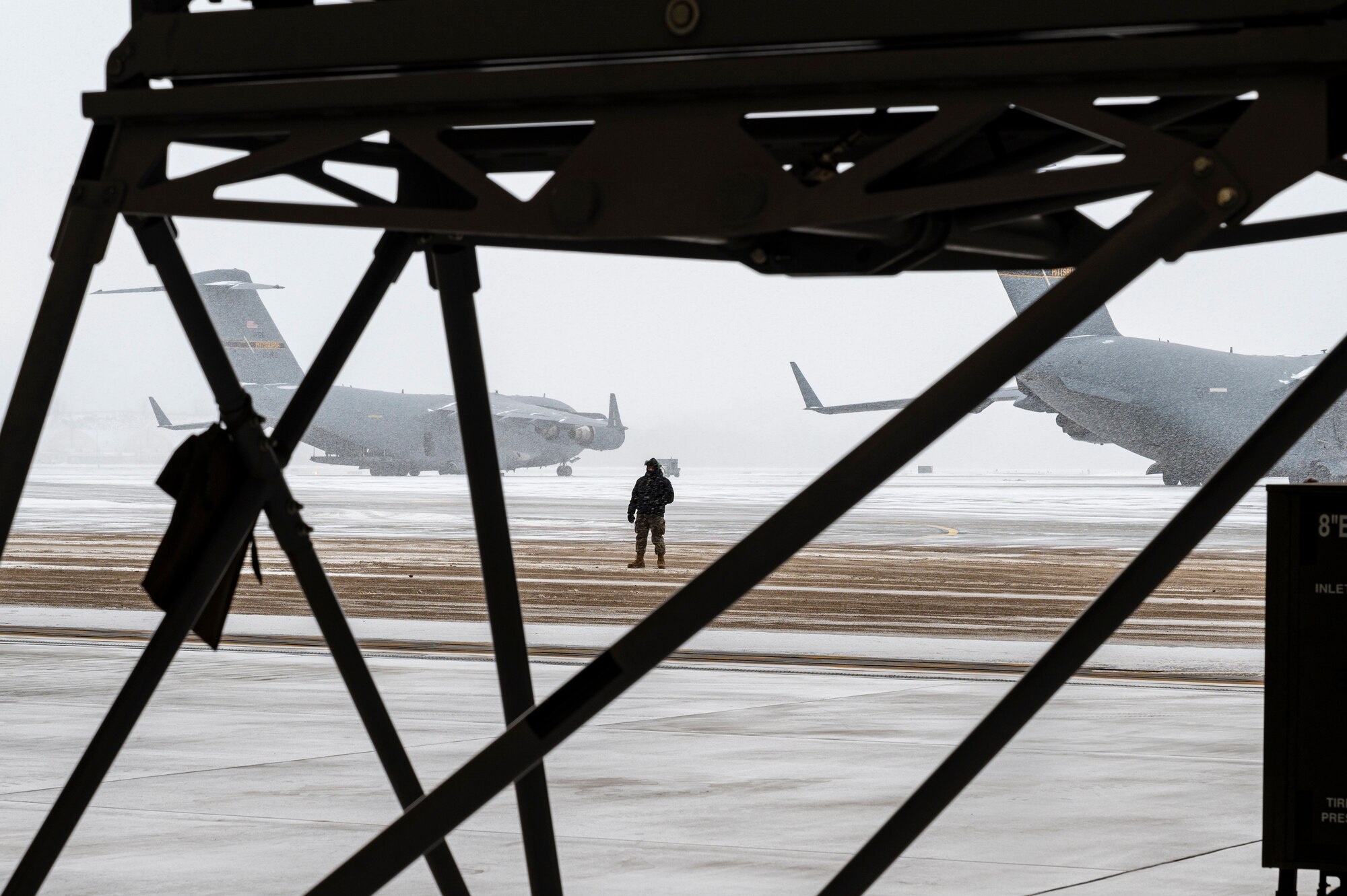 Senior Airman Elijah Turner, 911th Aircraft Maintenance Squadron crew chief, relays information to the tow team supervisor while they tow a C-17 Globemaster III aircraft from the two-bay hangar onto the flight line at the Pittsburgh International Airport Air Reserve Station, Pennsylvania, Jan. 20, 2022.