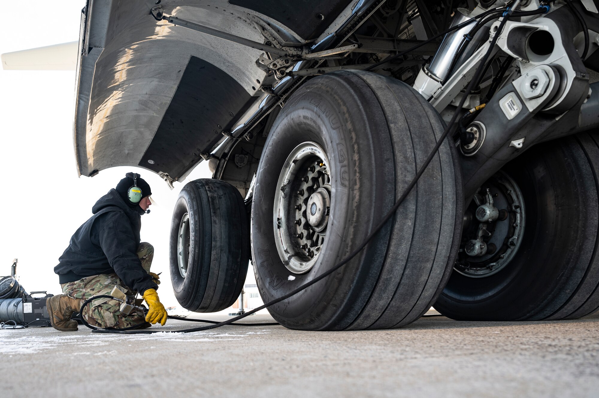 Master Sgt. John Thompson, 911th Aircraft Maintenance Squadron crew chief, raises the back part of the landing gear while preparing to change a tire on a C-17 Globemaster III at the Pittsburgh International Airport Air Reserve Station, Pennsylvania, Jan. 11, 2022.