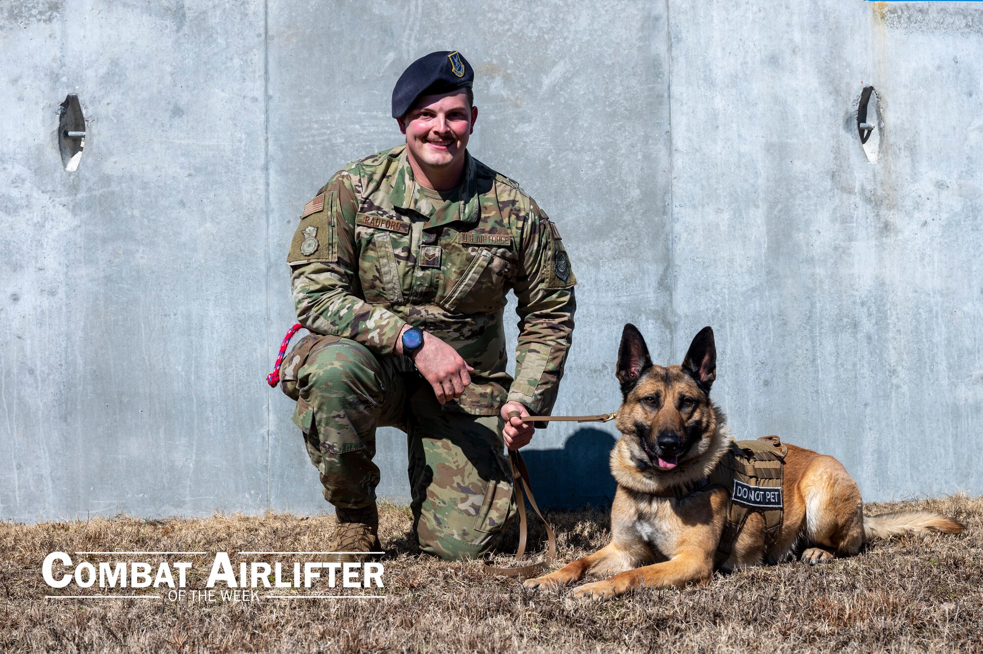 An Airman poses for a photo with his military working dog