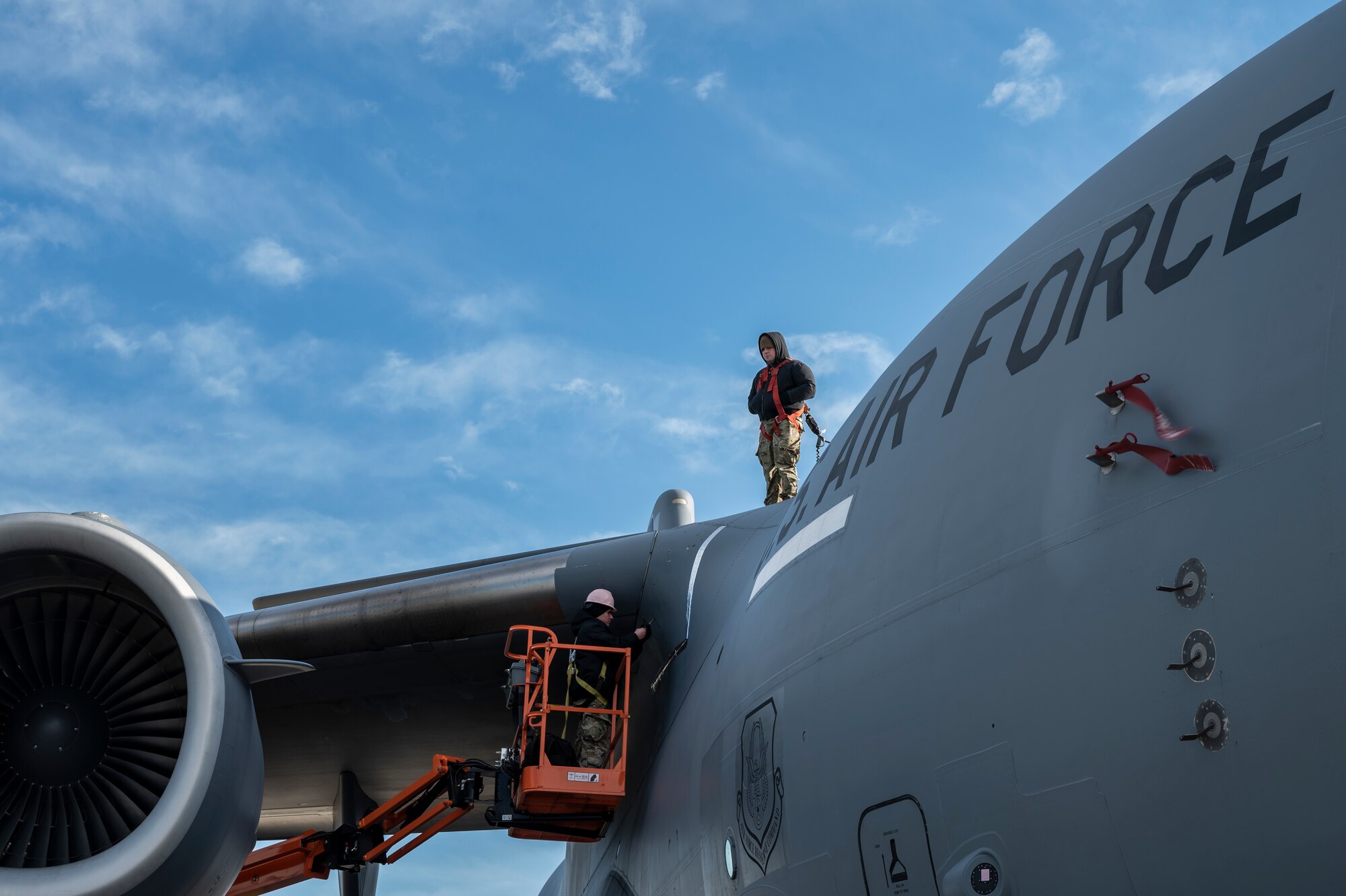 Staff Sgt. Mateo Gomez and Master Sgt. Dustin Dickinson, 911th Aircraft Maintenance Squadron instrument and flight controls technicians, reattach a panel on a C-17 Globemaster III after inspecting wires at the Pittsburgh International Airport Air Reserve Station, Pennsylvania, Jan. 3, 2022.