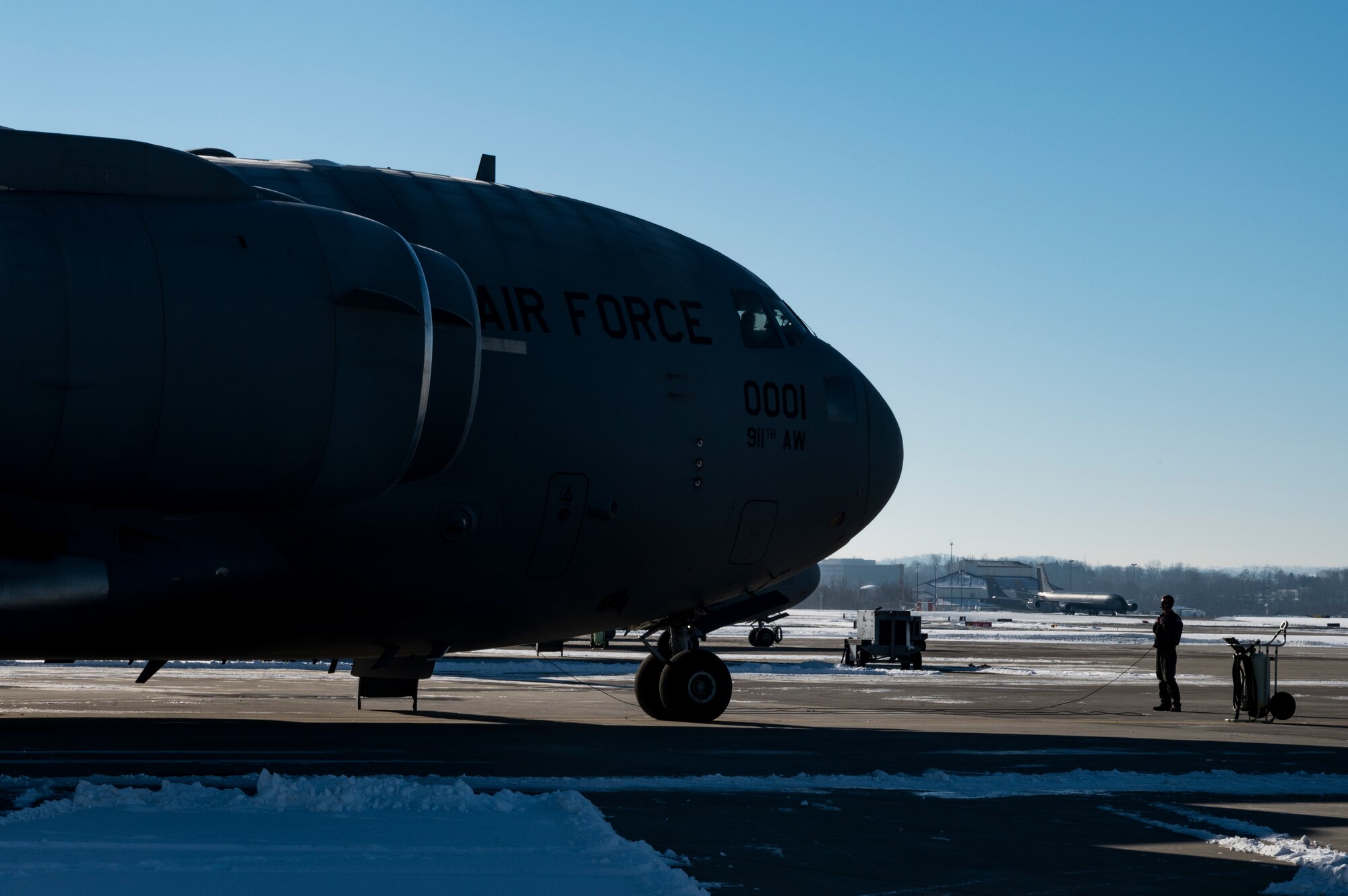 Staff Sgt. Steven Strobel, 758th Airlift Squadron loadmaster, talks with aircrew while conducting a pre-flight inspection on a C-17 Globemaster III before a training mission at the Pittsburgh International Airport Air Reserve Station, Pennsylvania, Jan. 27, 2022