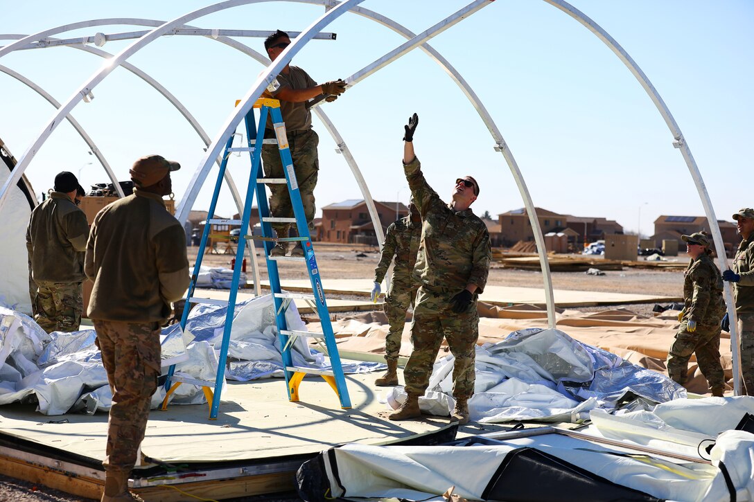 Airmen disassemble tents.