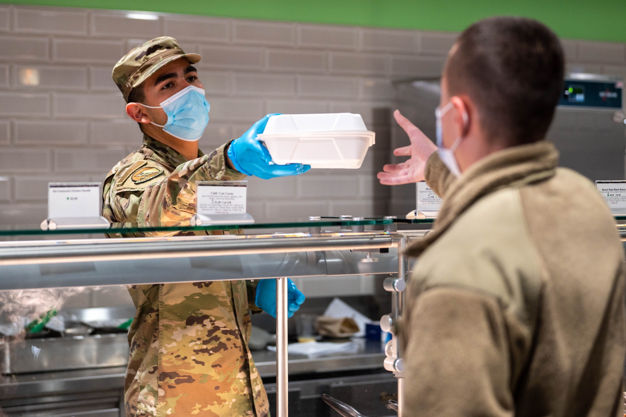 Airman serving food to a customer.