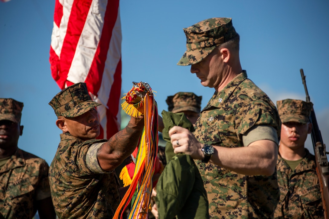 U.S. Marine Corps Sgt. Maj. John E. Bejarano, left, sergeant major, and Lt. Col. James R. Arnold, right, commanding officer, both with 3d Littoral Anti-Air Battalion, 3d Marines, 3d Marine Division, uncase the colors of 3d LAAB during an activation ceremony on Marine Corps Base Hawaii, Feb. 11, 2022. 3d LAAB is designed to train and employ air defense, air surveillance, early warning, air control, and forward rearming and refueling capabilities. The battalion activated in accordance with Force Design 2030 as 3d Marines prepares to become the U.S. Marine Corps’ inaugural Marine Littoral Regiment.