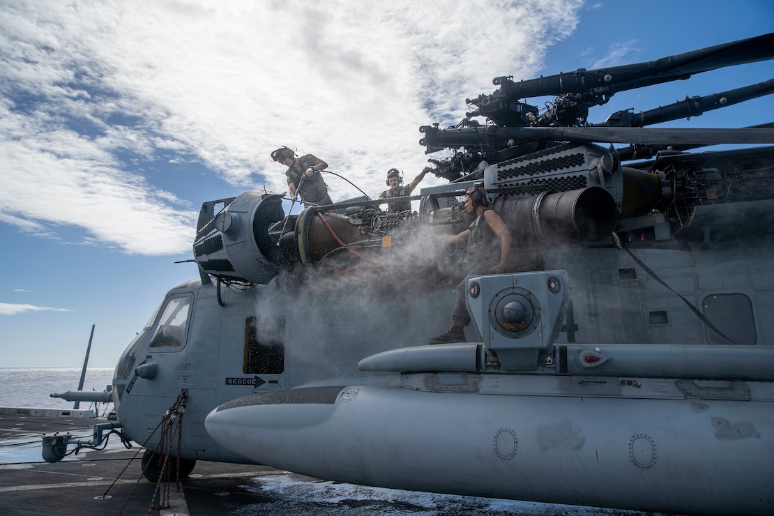 U.S. Marines assigned to Marine Medium Tiltrotor Squadron 165 (Reinforced), 11th Marine Expeditionary Unit, power wash a CH-53E Super Stallion engine during aircraft wash-downs aboard the amphibious transport dock USS Portland (LPD 27), Feb. 10. Portland, part of the USS Essex Amphibious Ready Group, along with the 11th MEU, is operating in the U.S. 7th Fleet area of operations to enhance interoperability with alliances and partners and serve as a ready response force to ensure maritime security and a free and open Indo-Pacific region.