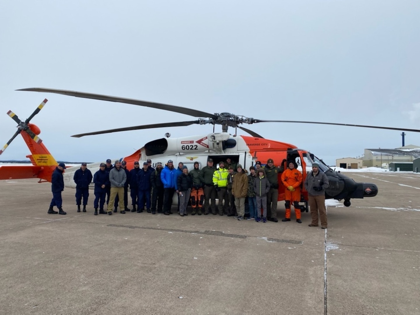 Members from Air Station Traverse City and Station Marquette, National Park Service Rangers and local ice climbing rescue volunteers gather around an MH-60 Jayhawk during helicopter familiarization training at the airport in Marquette, Mich. Feb. 5, 2022. The training helps local responders know what to expect when helicopters are involved in a rescue case. U.S. Coast Guard photo by Lt. j.g. Brandon Skelly.