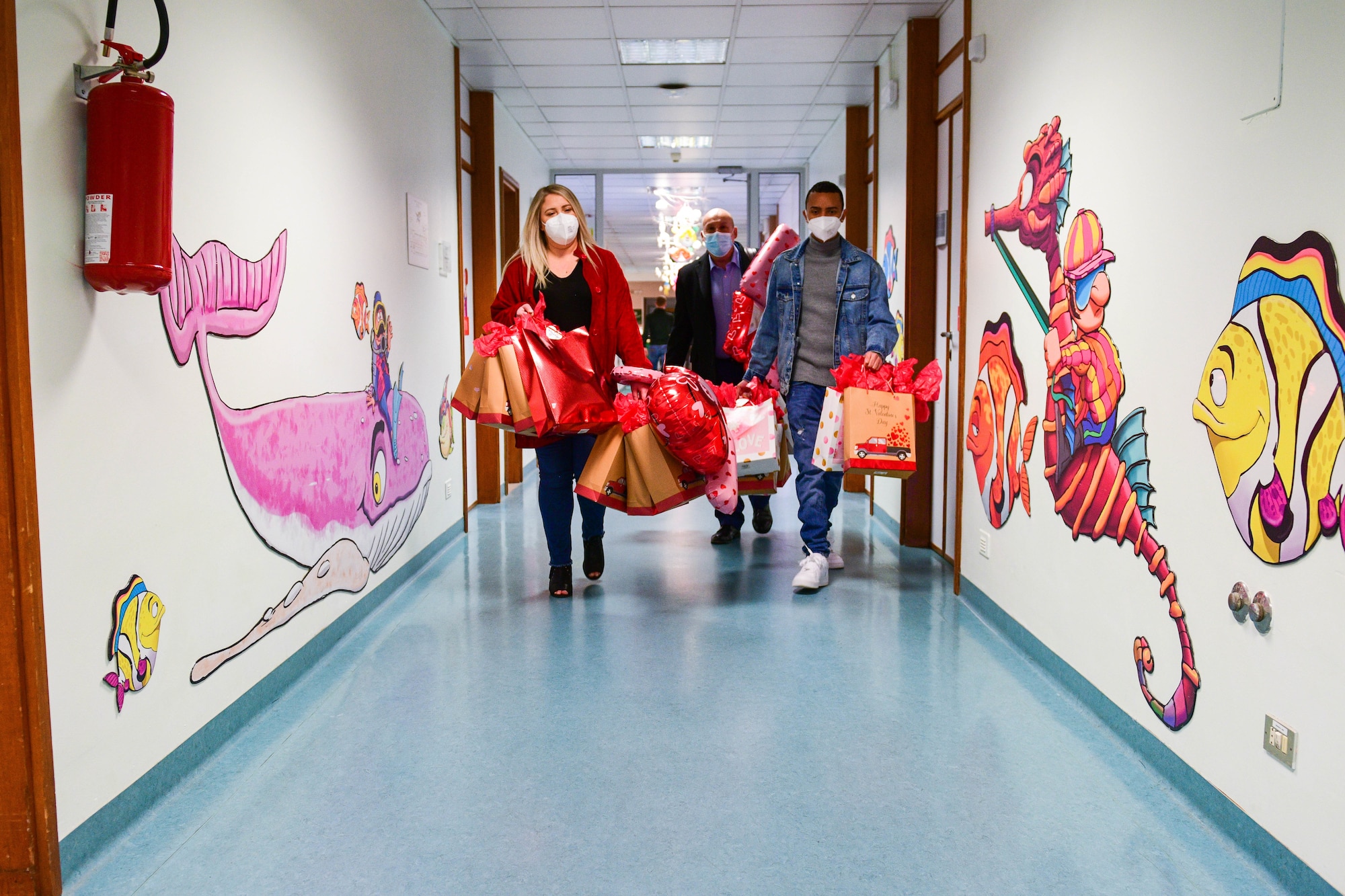 U.S. Air Force Staff Sgt. Hannah Hannas, 31st Security Forces Squadron Pass & Registration assistant noncommissioned officer in charge, left, Gianluca Valeri, 31st SFS Allied Forces Italy licensing assistant, middle, and Senior Airman Nelson Roman, 31st SFS Pass & Reg clerk, bring Valentine’s Day gift bags to children in the pediatric oncology ward of the Pordenone Hospital, in Pordenone, Italy, Feb. 14, 2022. Due to COVID-19, the donations were given to the children in the lobby area. The gift bags were delivered to children ages 9 months to 15 years old and each gift bag was tailored to the age of the child. (U.S. Air Force photo by Senior Airman Brooke Moeder)