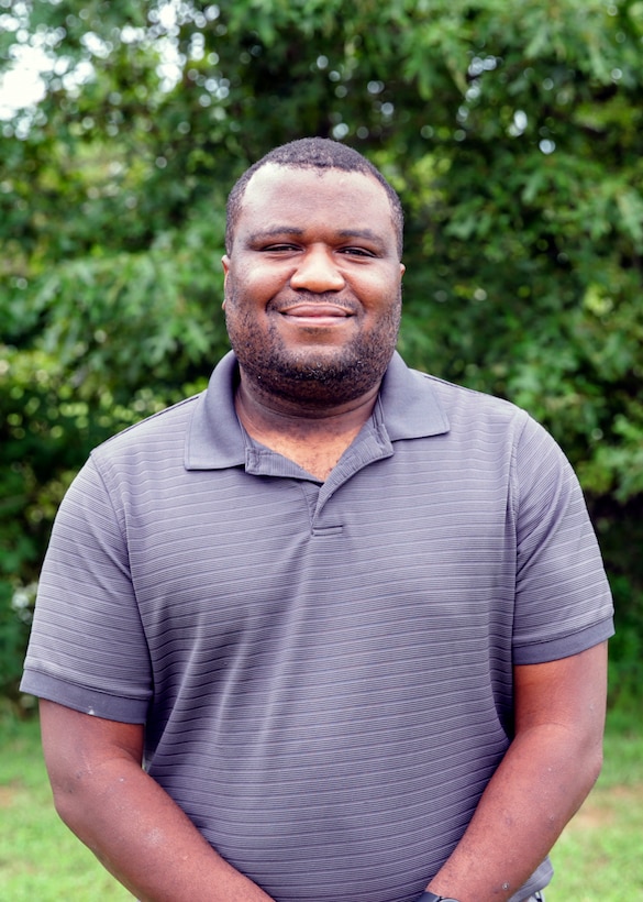 NSWC IHD employee Albert Wright standing in front of trees.