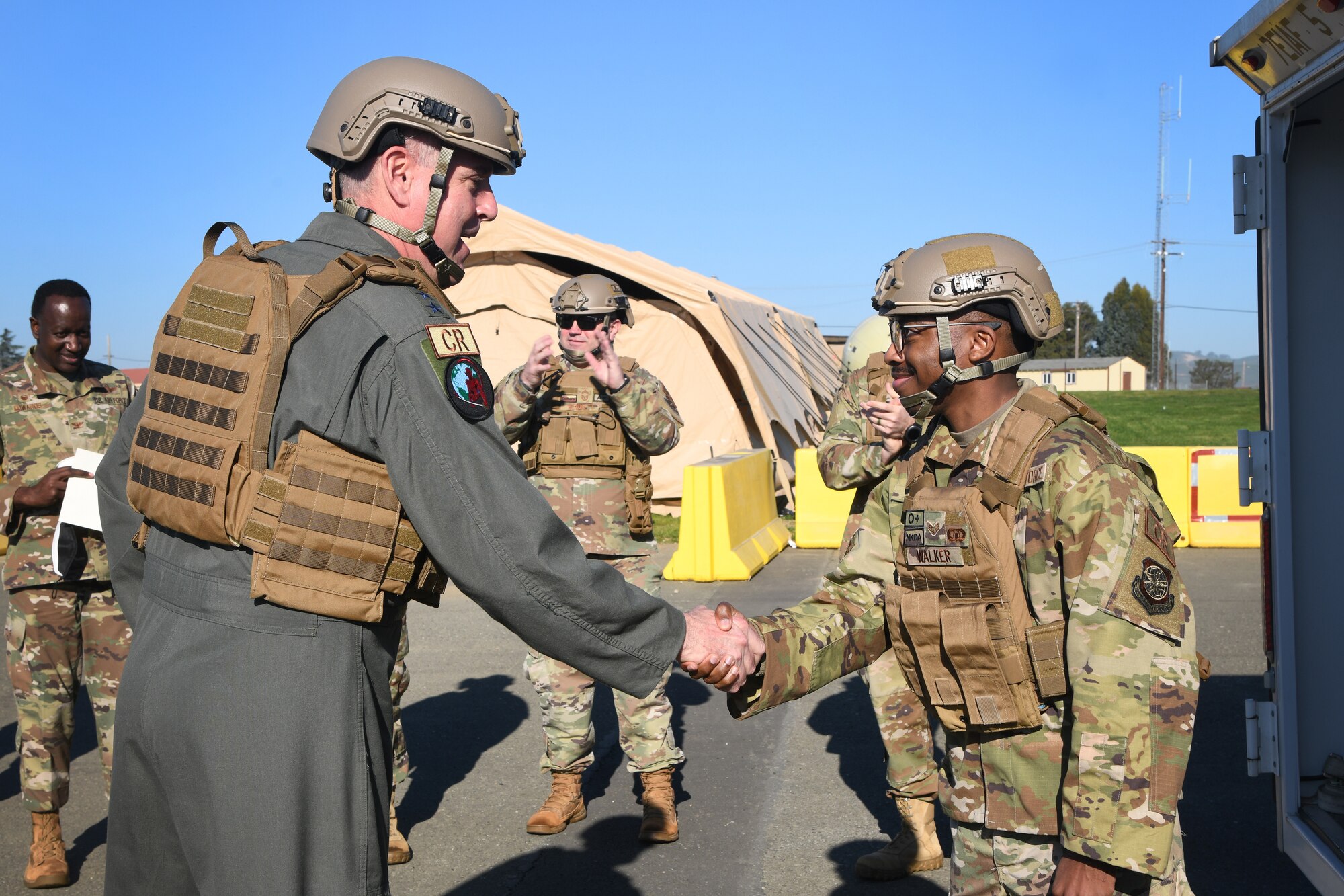 U.S. Air Force Gen. Mike Minihan, commander of Air Mobility Command, coins Senior Airman Trevon Walker, 921st Contingency Response Squadron CR air traffic controller, Feb. 11, 2022, at Travis Air Force Base, California. Minihan recognized several Airmen from the 621st Contingency Response Wing including Walker who deployed May 2021 to support the Afghanistan retrograde and deployed again in August to Kabul, Afghanistan, in support of Operation Allies Refuge. (U.S. Air Force photo by Master Sgt. Melissa B. White)