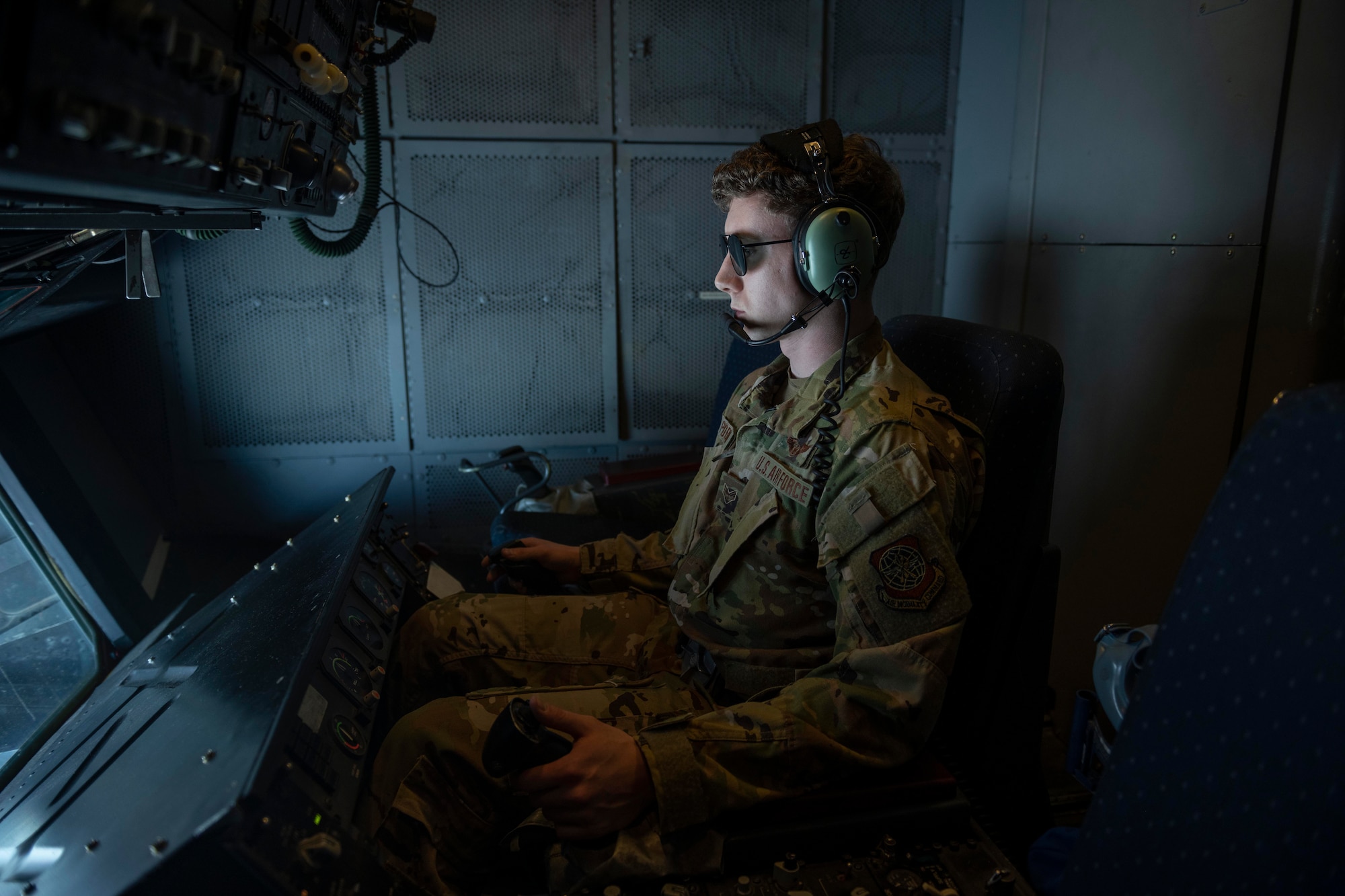 an airman controls the refueling boom, he's wearing sunglasses