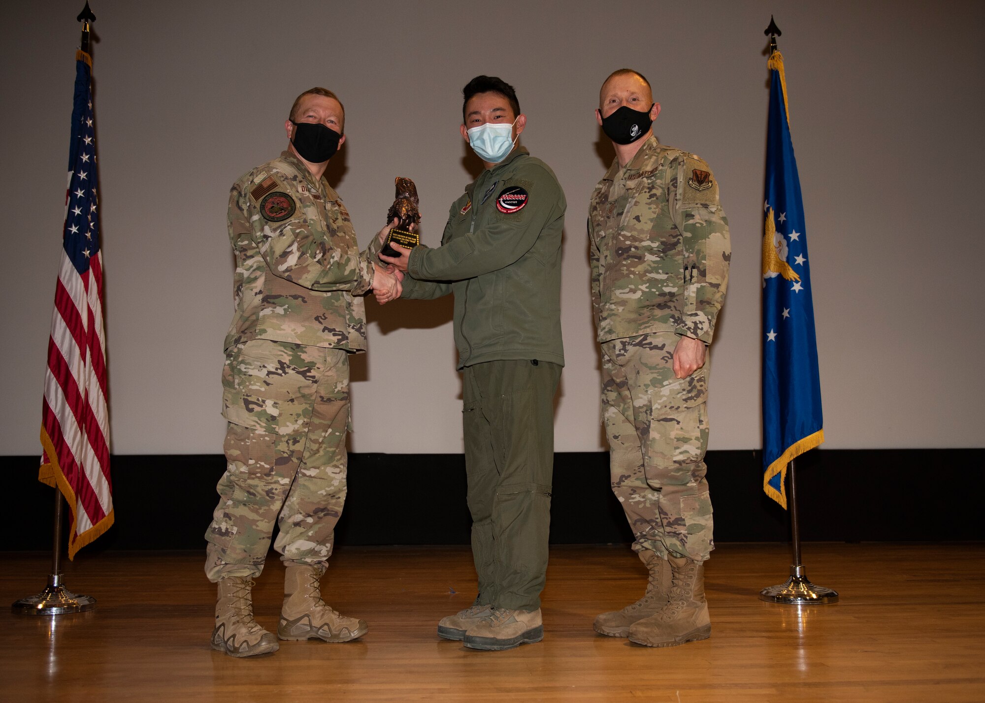 Two Airmen and an Aircrew member from Republic of Singapore Air Force pose for a photo with a trophy.