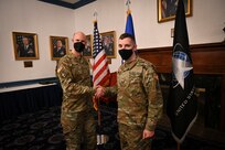 U.S. Army Maj. Mark T. Anderson, commander of the Naval Support Facility- Thurmont special missions command, coins and congratulates U.S. Army Sgt. Harly D. Gomme, White House Communications Agency satellite communications systems operator, after Gomme’s inter-service transfer ceremony into the U.S. Space Force.