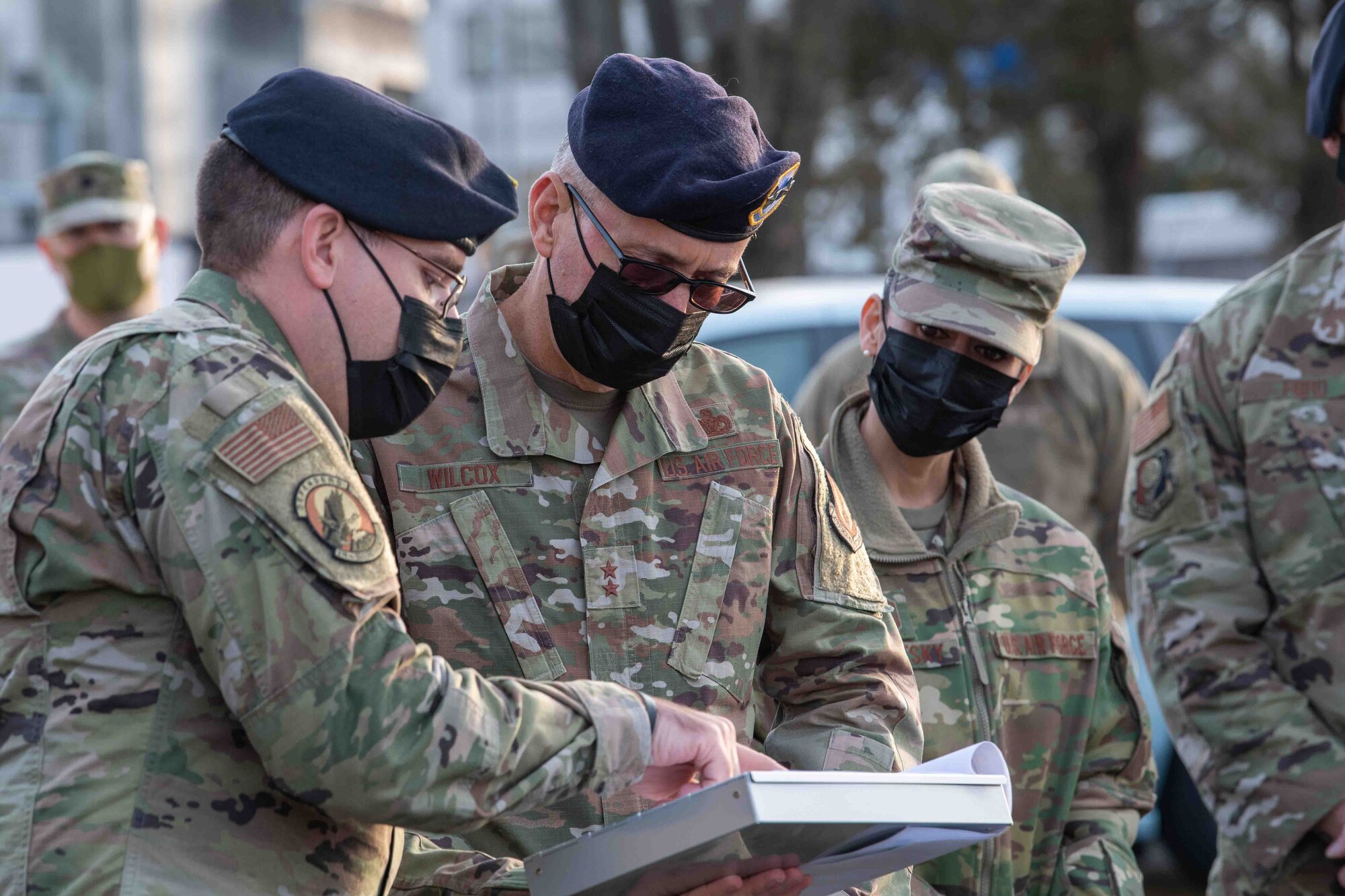 Tech. Sgt. James Greuel, left, 374th Security Forces Squadron flight sergeant, briefs Maj. Gen. Tom Wilcox, Air Force Installation and Mission Support Center commander, and Chief Master Sgt. Hope Skibitsky, AFIMSC command chief, on the importance of the Fussa gate during a site visit at Yokota Air Base, Japan, Feb. 9, 2022.