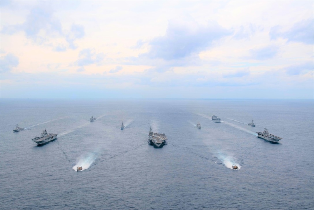 Ships of the America and Essex Amphibious Ready Groups, and Carrier Strike Group (CSG) 3, sail in formation with the Japan Maritime Self-Defense Force during exercise Noble Fusion, led by Combined Task Force 79 (3rd Marine Expeditionary Brigade) and CTF 76. Front row: Landing craft, utility from USS Essex (LHD 2). Second row, left to right: USS America (LHA 6), USS Abraham Lincoln (CVN 72), Essex. Third row, left to right: USS Dewey (DDG 105), JS Kongō (DDG 173), USS Mobile Bay (CG 53), USS Spruance (DDG 111). Back row, left to right: USS Ashland (LSD 48), USS Miguel Keith (ESB 5). Noble Fusion highlights that Navy and Marine Corps forward-deployed stand-in naval expeditionary forces can rapidly aggregate Marine Expeditionary Unit/Amphibious Ready Group teams at sea, along with a carrier strike group, as well as other joint force elements and allies, in order to conduct lethal sea-denial operations, seize key maritime terrain, guarantee freedom of movement, and create advantage for US, partner and allied forces. Naval Expeditionary forces conduct training throughout the year, in the Indo-Pacific, to maintain readiness. (U.S. Navy photo)