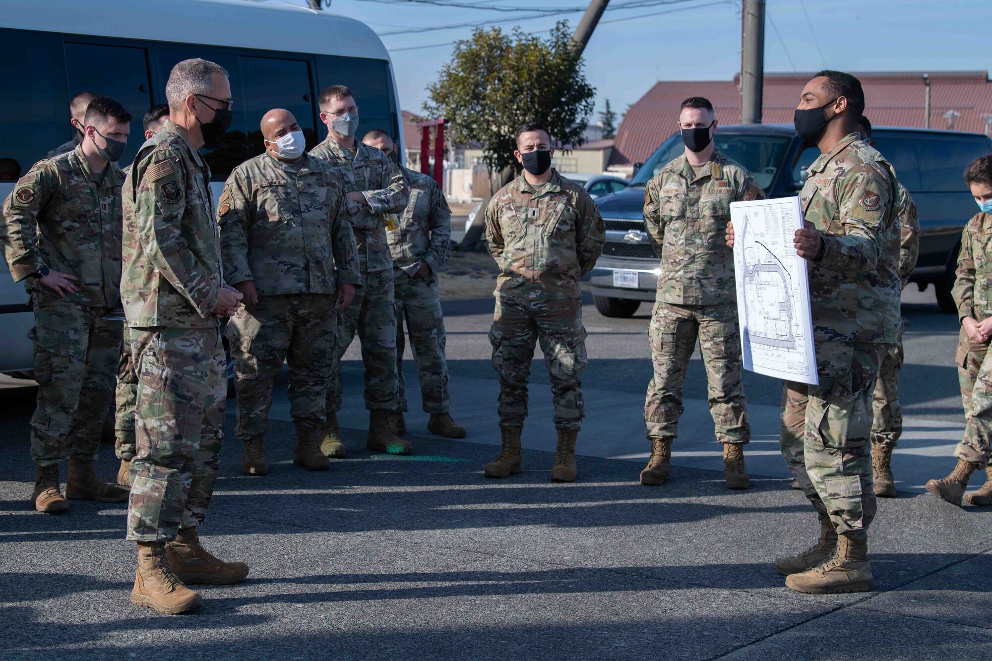 Second Lt. David Rochester, right, 374th Civil Engineer Squadron host nation construction officer-in-charge, briefs Maj. Gen. Tom Wilcox, Air Force Installation and Mission Support Center commander, on upcoming construction projects during a site visit at Yokota Air Base, Japan, Feb. 9, 2022.